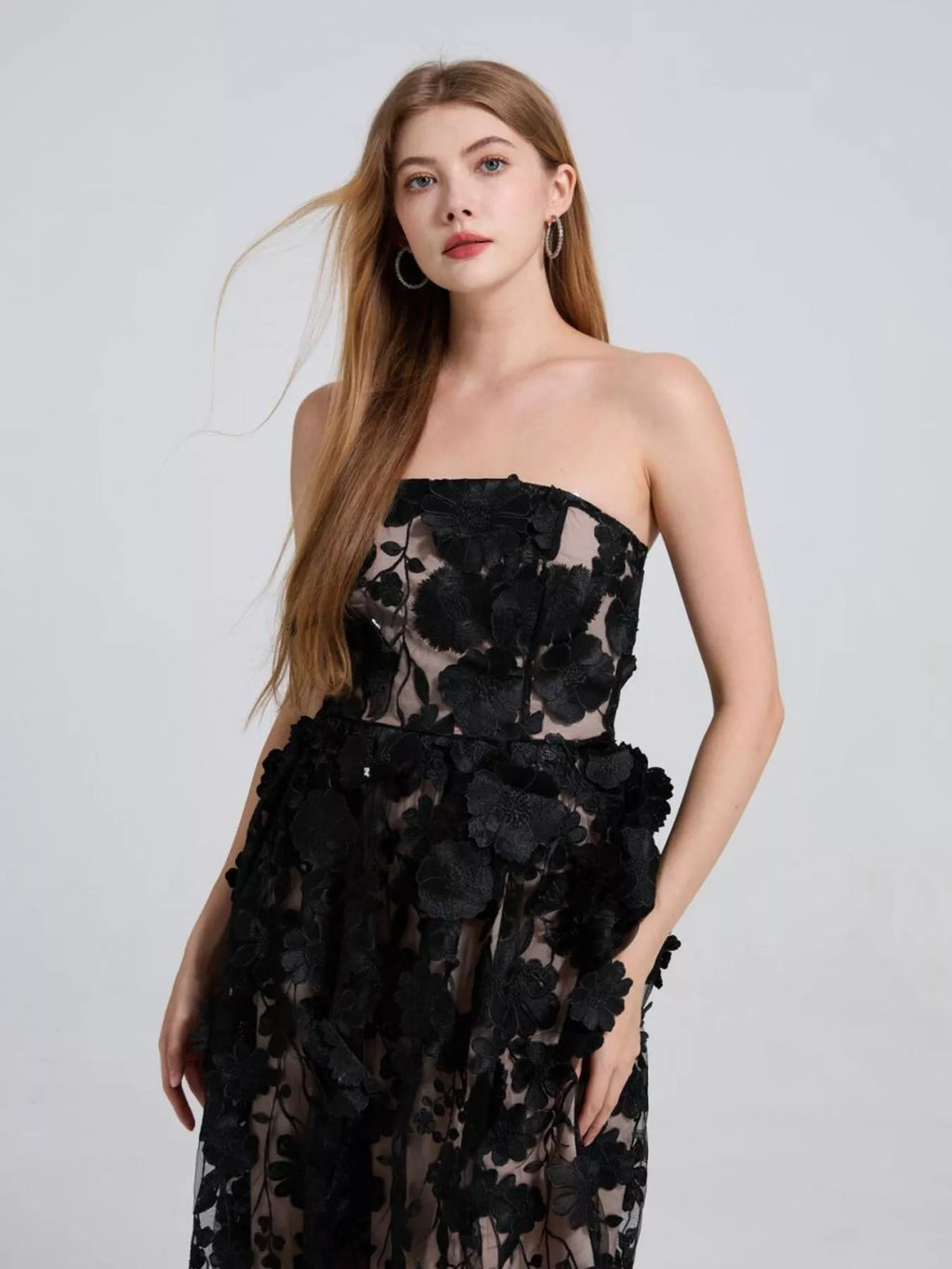 Black strapless midi dress close-up with clustered floral applique and sheer overlay