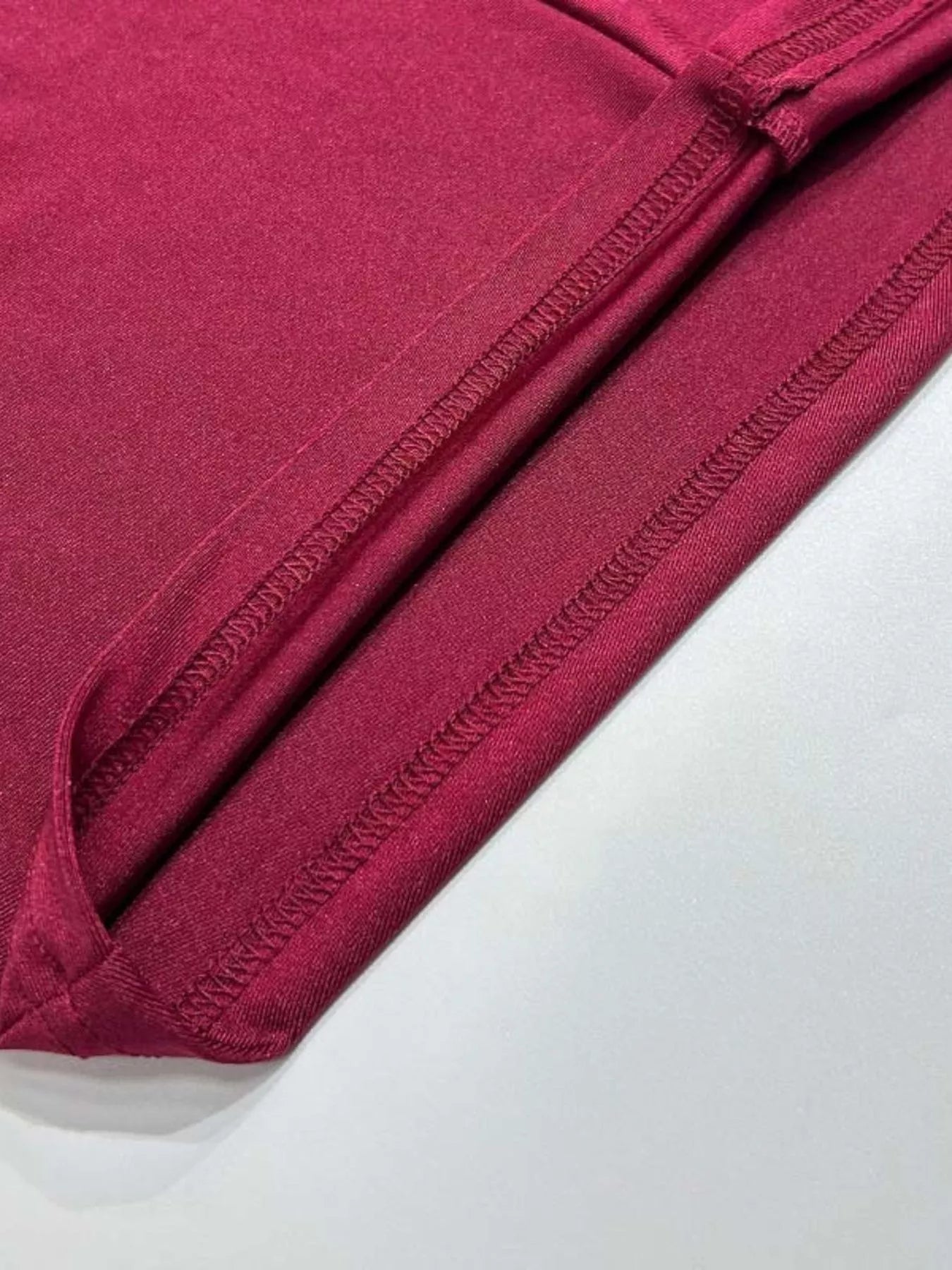 Burgundy maxi dress close-up of side seam ruching and smooth fabric texture