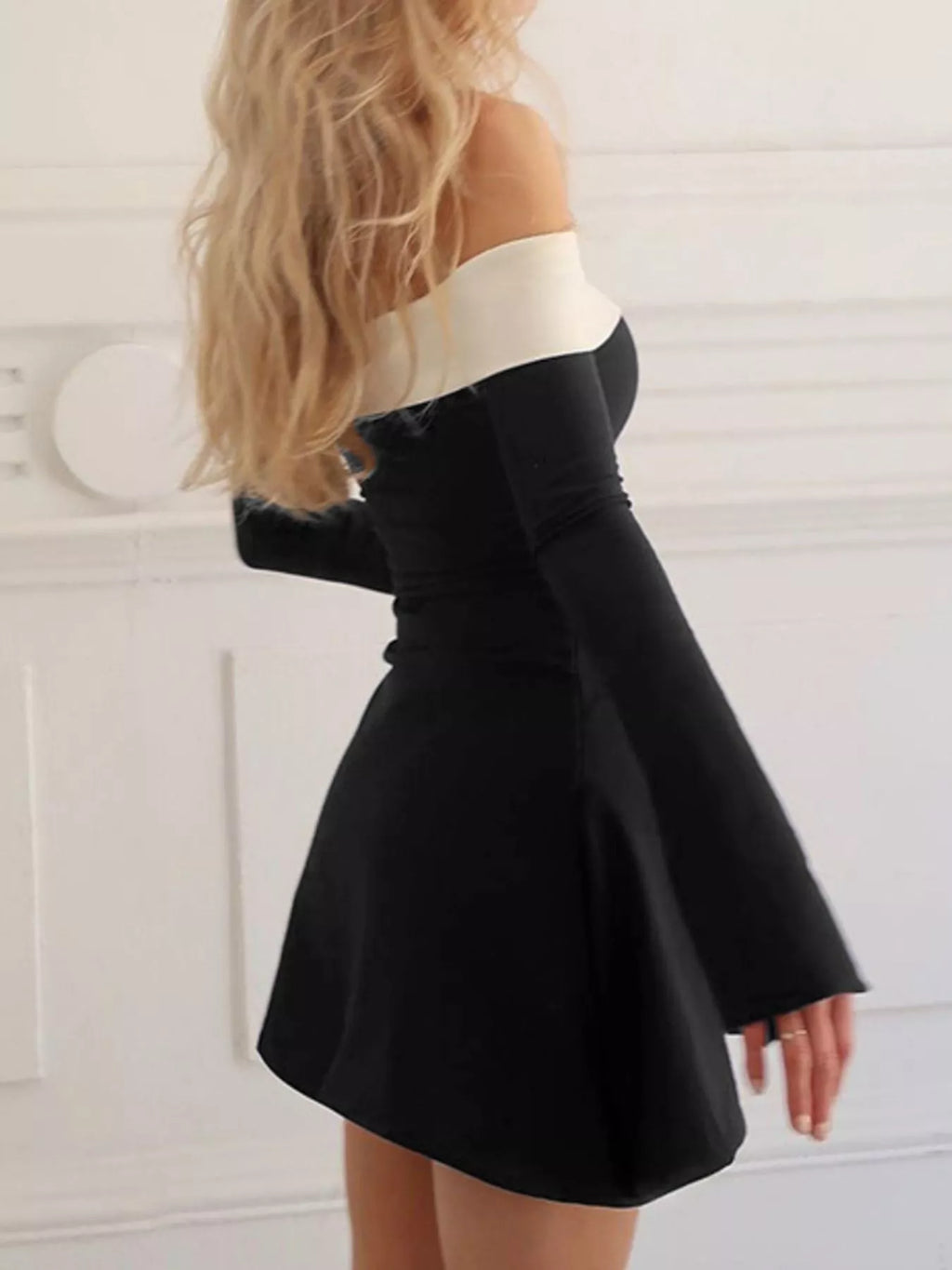Black off-shoulder mini dress with white band and long flared sleeve hem