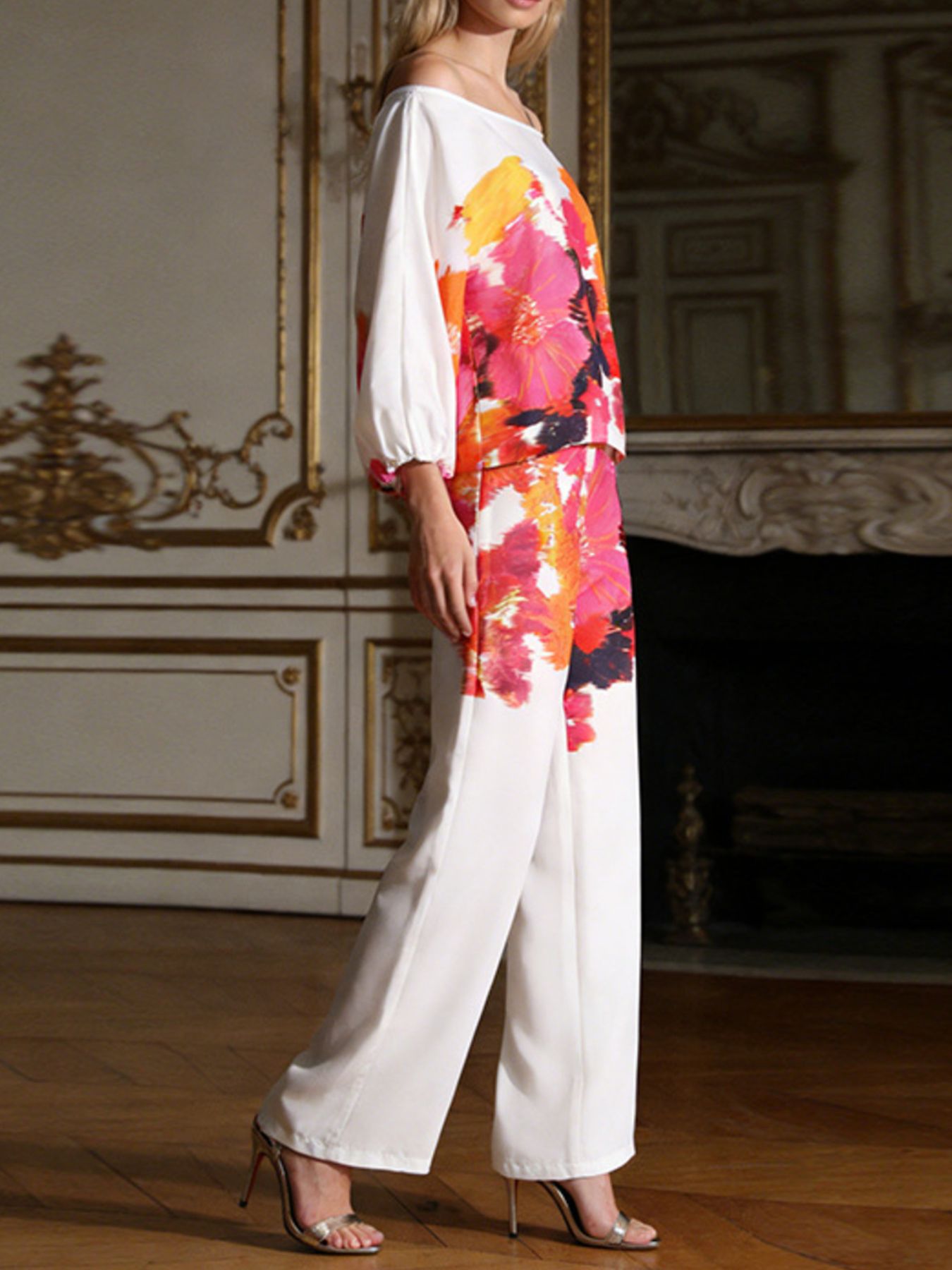 Side view of off-shoulder floral top with balloon sleeves and white wide-leg pants
