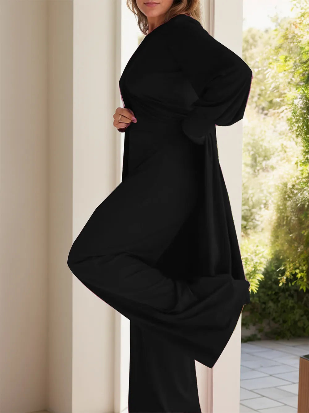Two-piece slit top and pants set, black, long sleeves and round neck, side view.