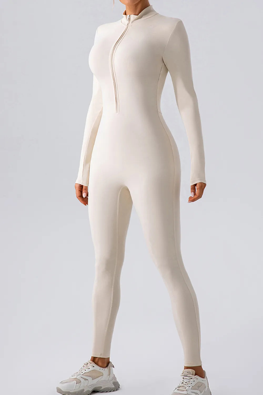 White active jumpsuit with mock neck half-zip front, long sleeves, full-length fitted legs.
