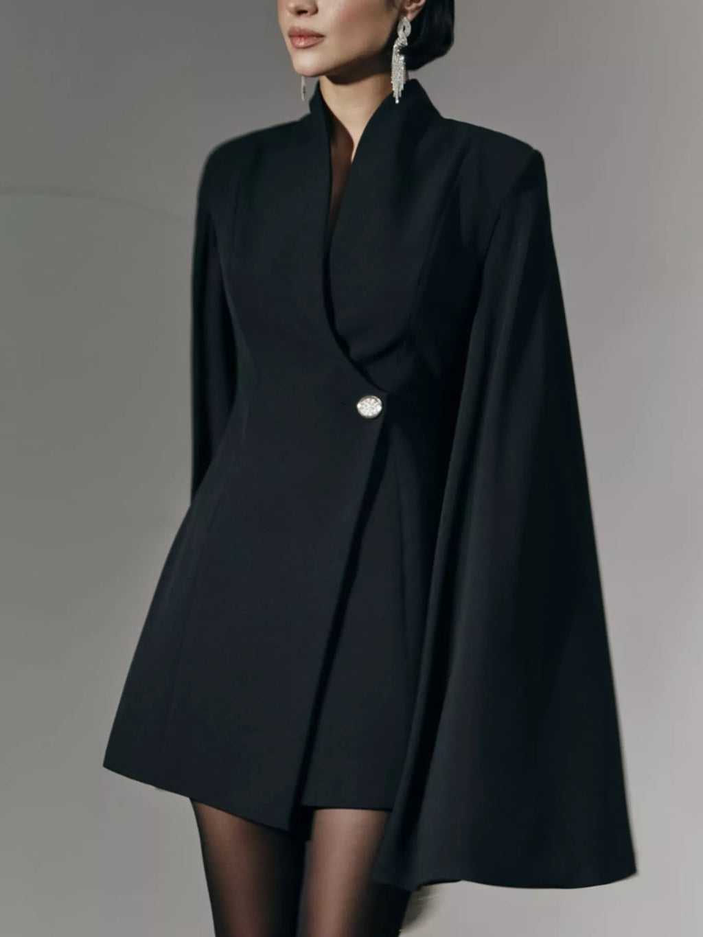 Black fitted mini blazer dress with cape sleeves, notched lapel, and single button