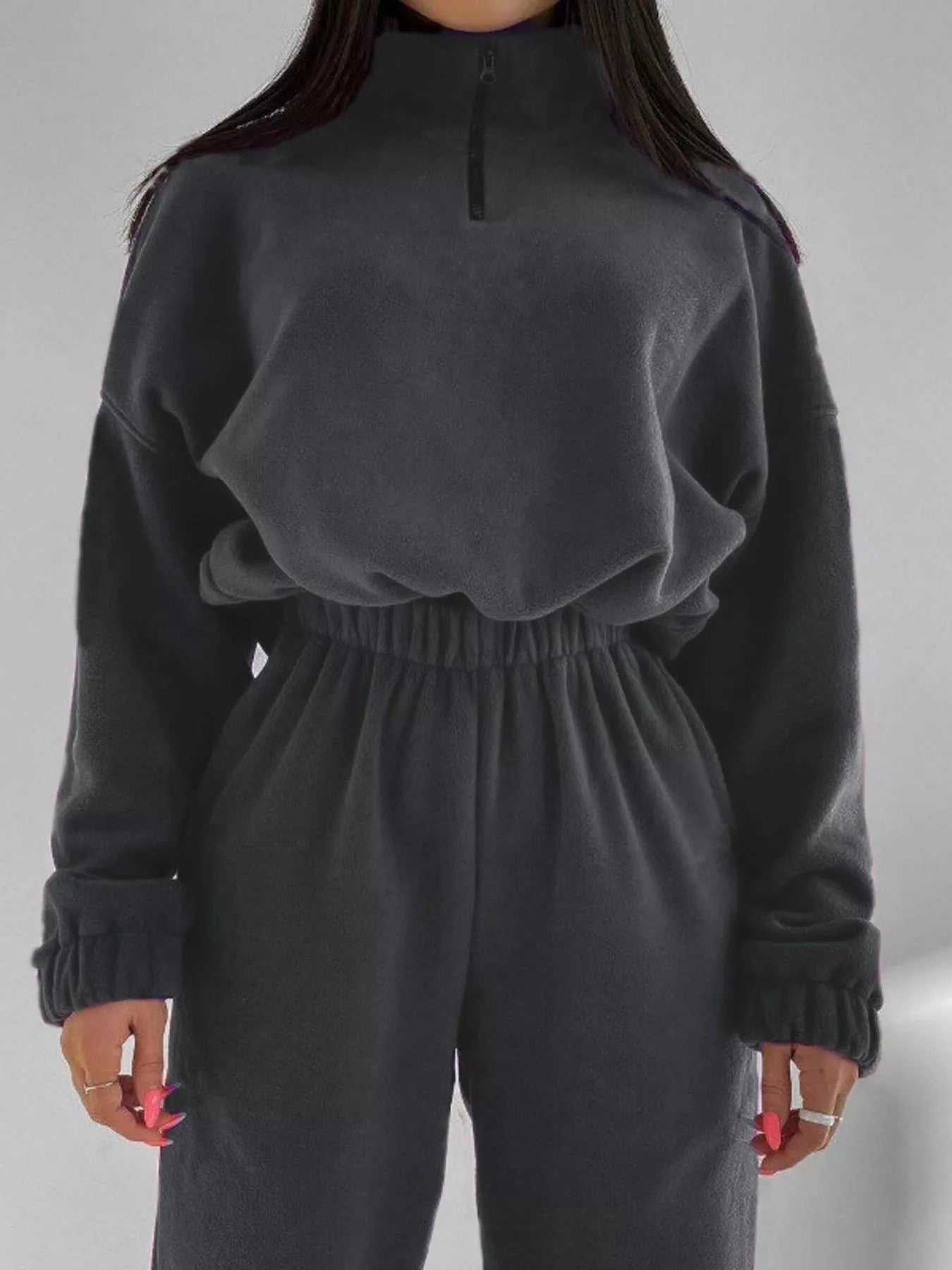 Dark gray quarter-zip sweatshirt and jogger pants set on a model, full outfit view.