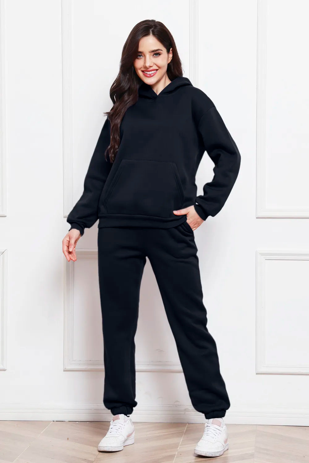 Hoodie and pants set in black with kangaroo pocket, drawstring hood, and joggers