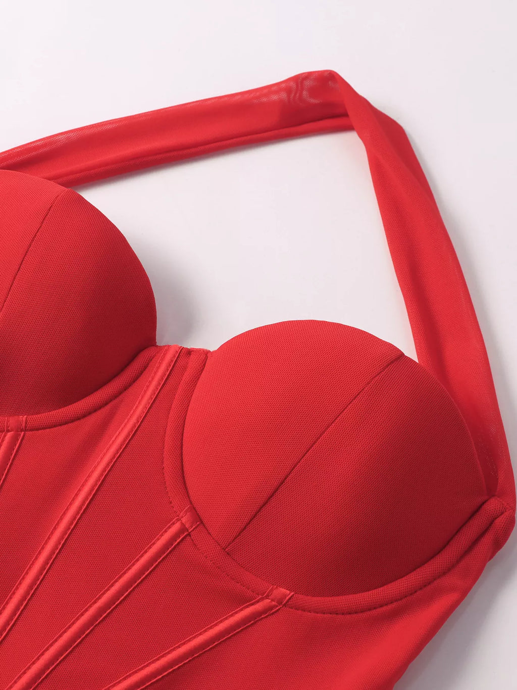 Close-up of red halter neckline and bust with ruched seams and molded cup shape