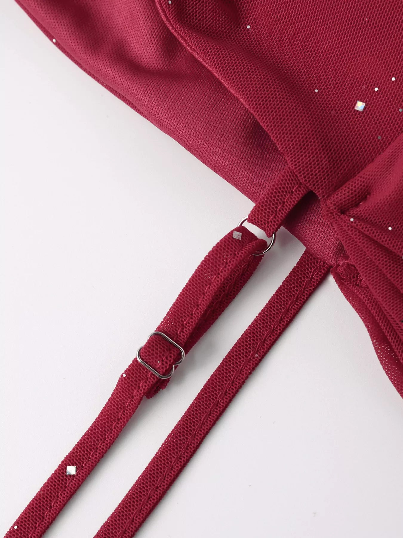 Wine red glitter sleeve close-up with textured mesh and clasped tie strap detail