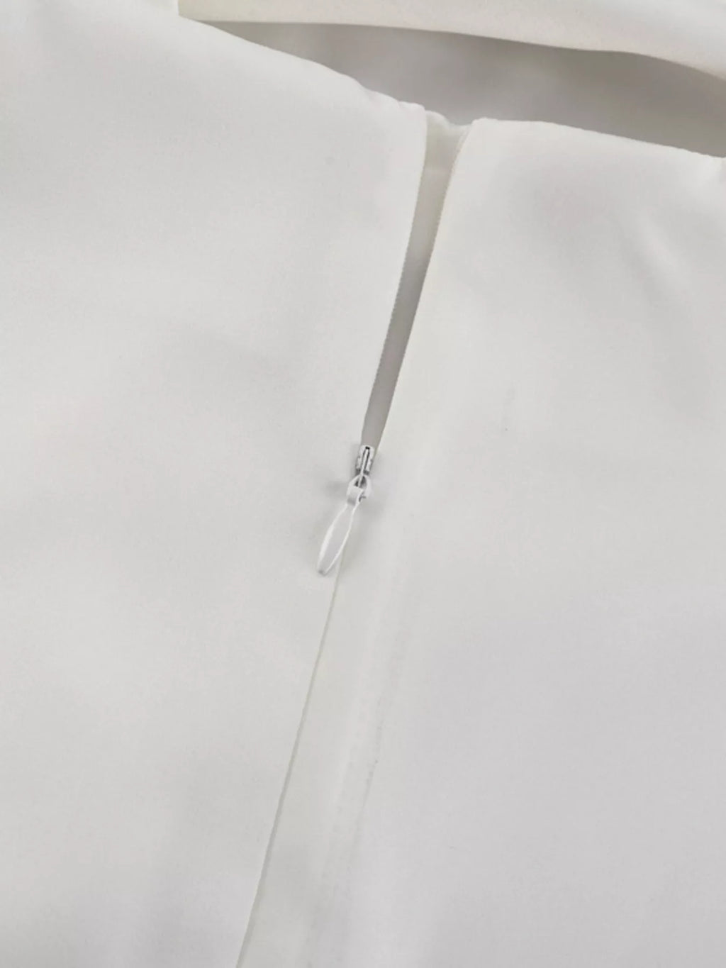 White halter dress close-up of thin straps and small back clasp hardware