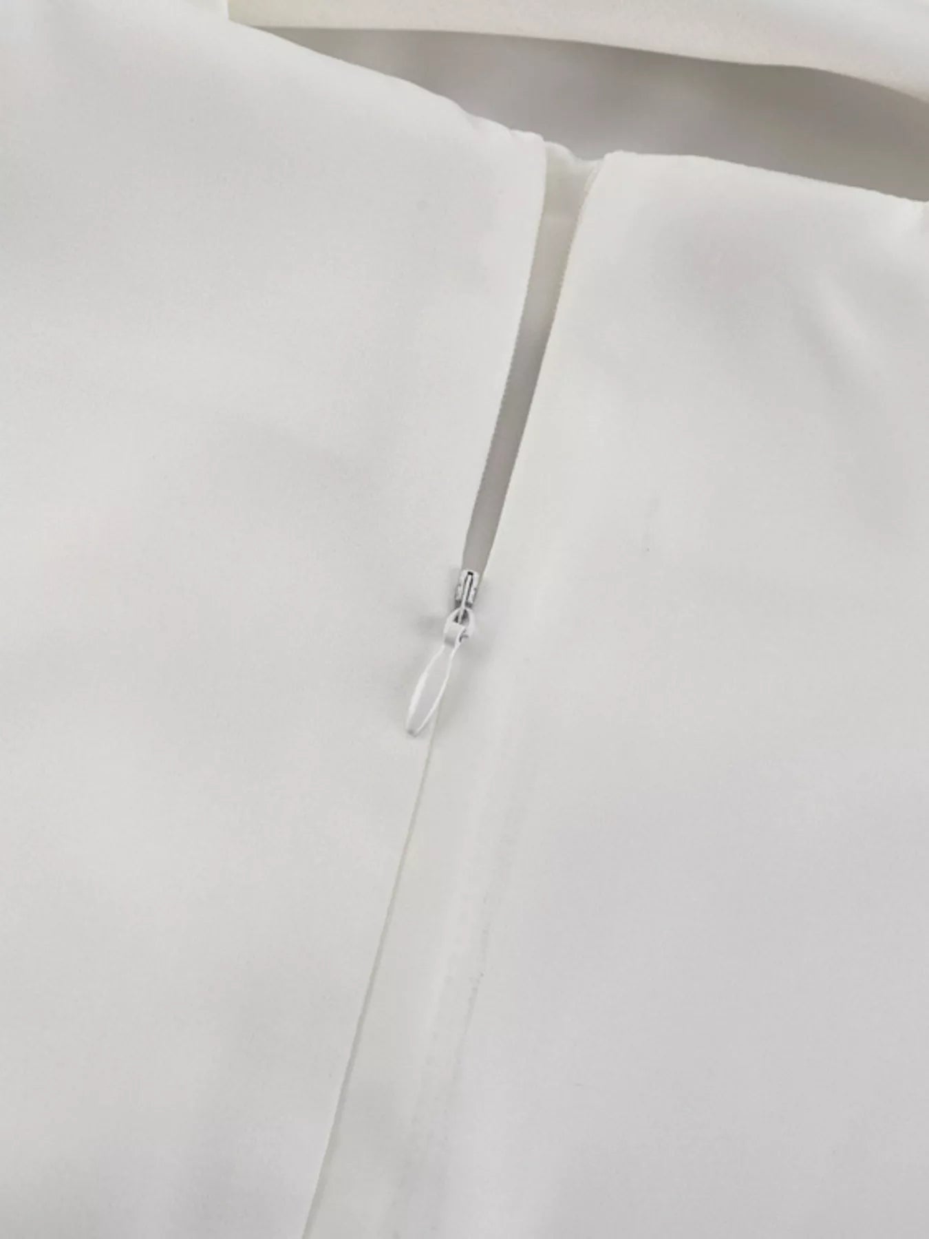 White halter dress close-up of thin straps and small back clasp hardware