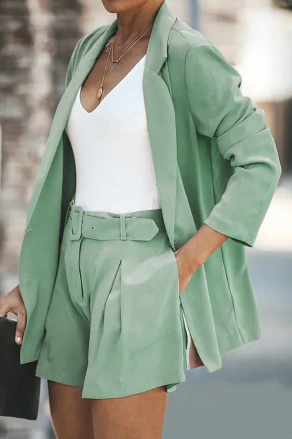 Two-piece blazer and shorts set in mint green; long blazer with flap pockets, belted tailored shorts.