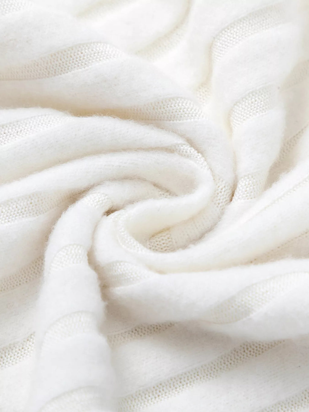White ribbed knit fabric close-up with soft drape and fine weave