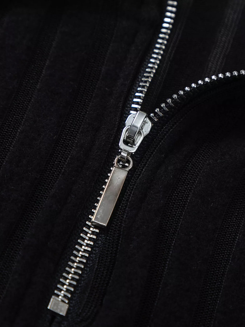 Black ribbed knit front zipper with silver metal pull and teeth