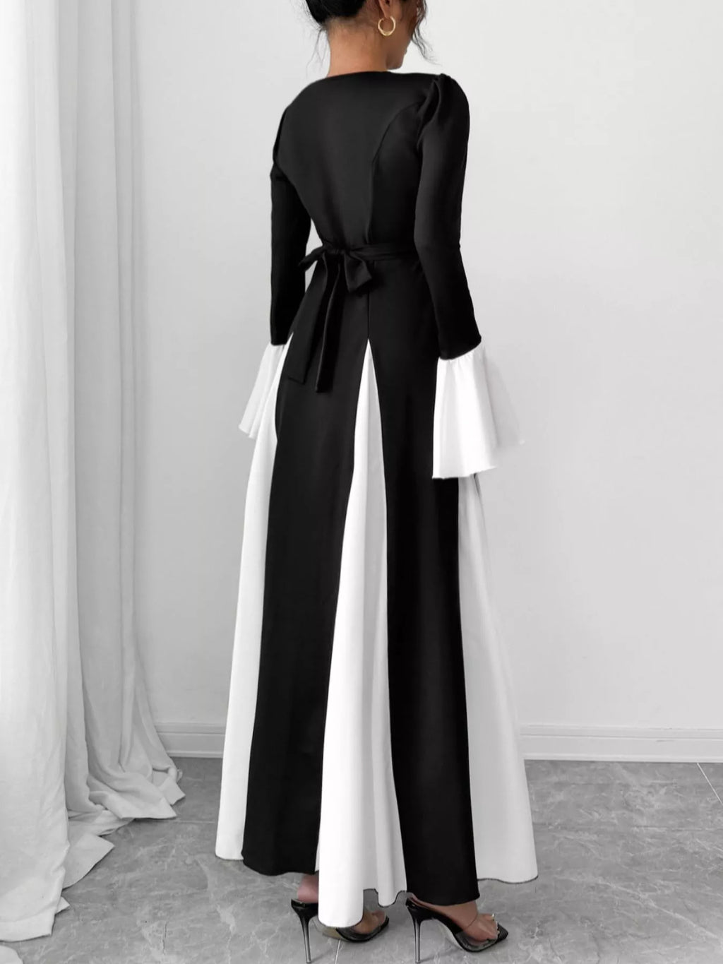 Black maxi dress, back view, tied waist, long sleeves, white contrast hem panels
