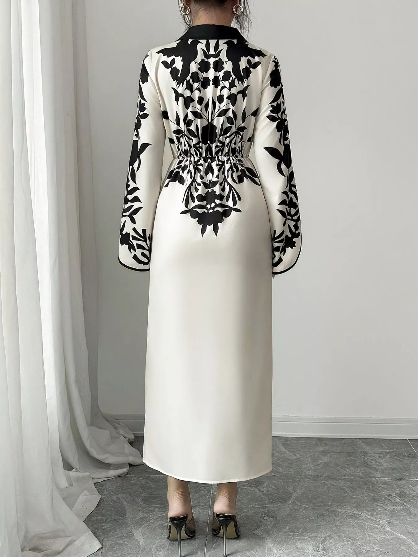 Back view of black-and-white floral wrap midi dress with long sleeves and waist tie
