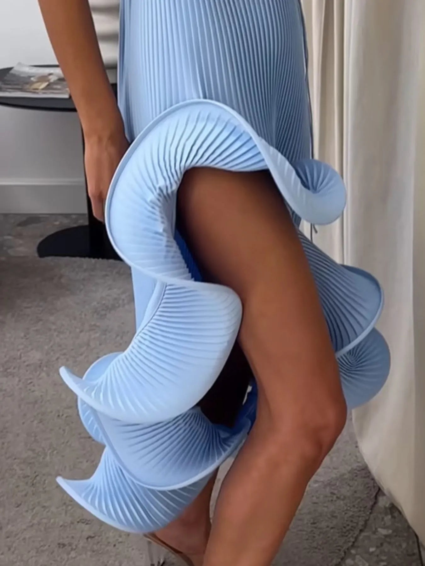 Blue ribbed sleeveless dress with ruffle hem, close view of large side ruffle layers