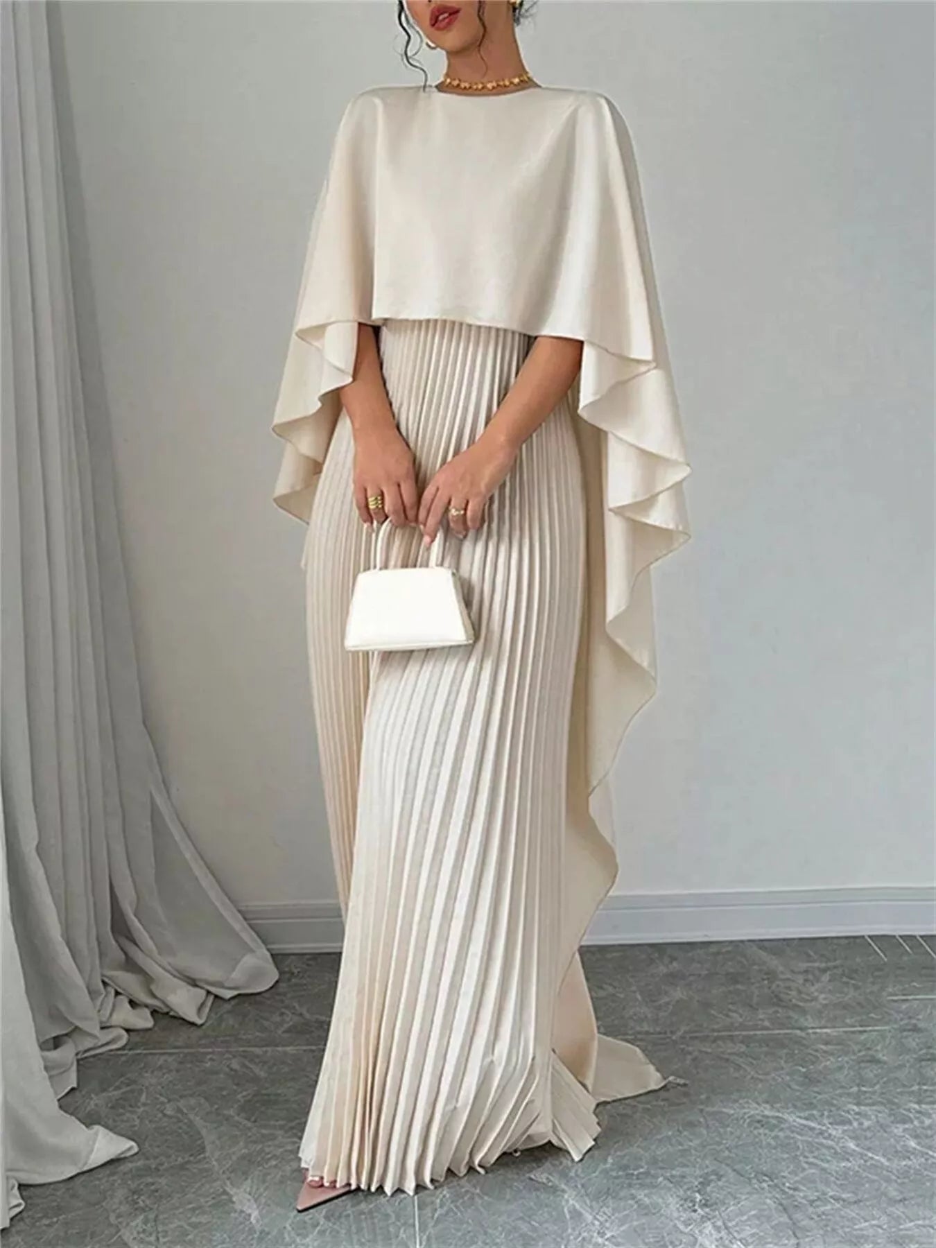 Cream cape pleated maxi dress with layered cape sleeves and long pleated column skirt