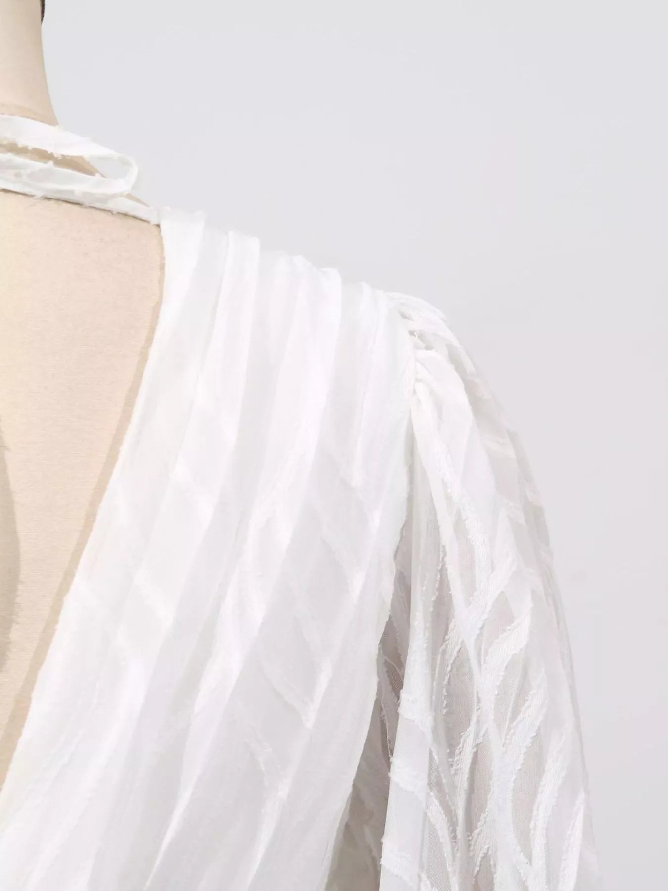White sheer sleeve ruffle with draped fabric and elastic cuff