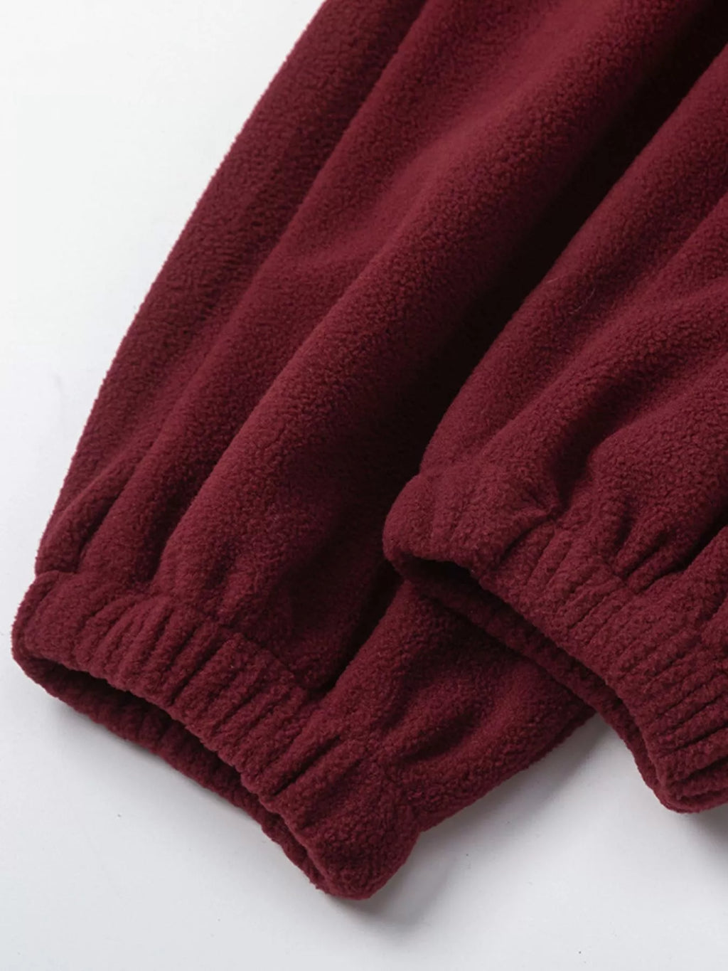 Burgundy fleece sweatshirt and jogger cuffs with ribbed trim and drawstring ends.