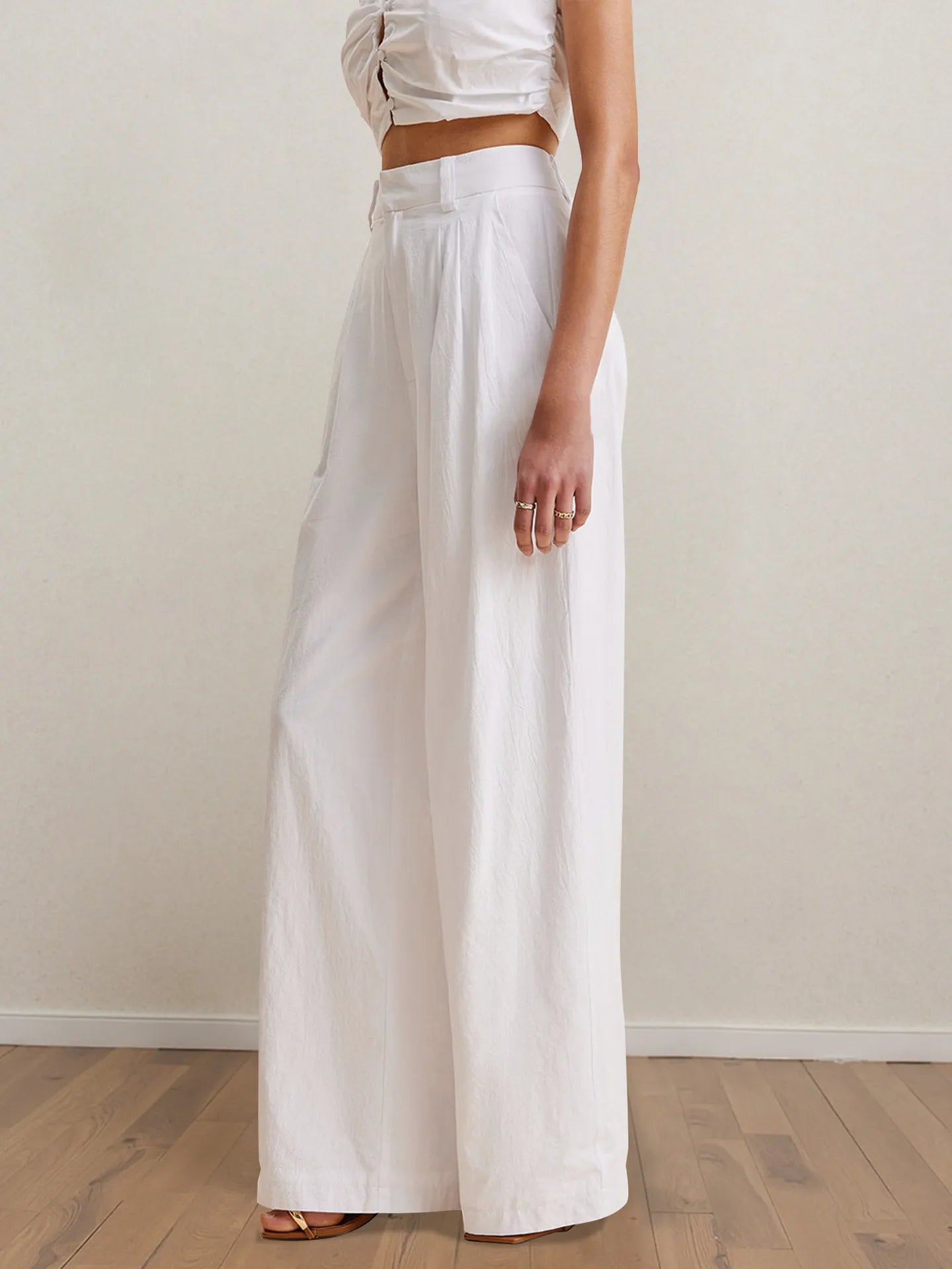 White high-waist wide-leg pants with pleats, paired with strapless peplum top.