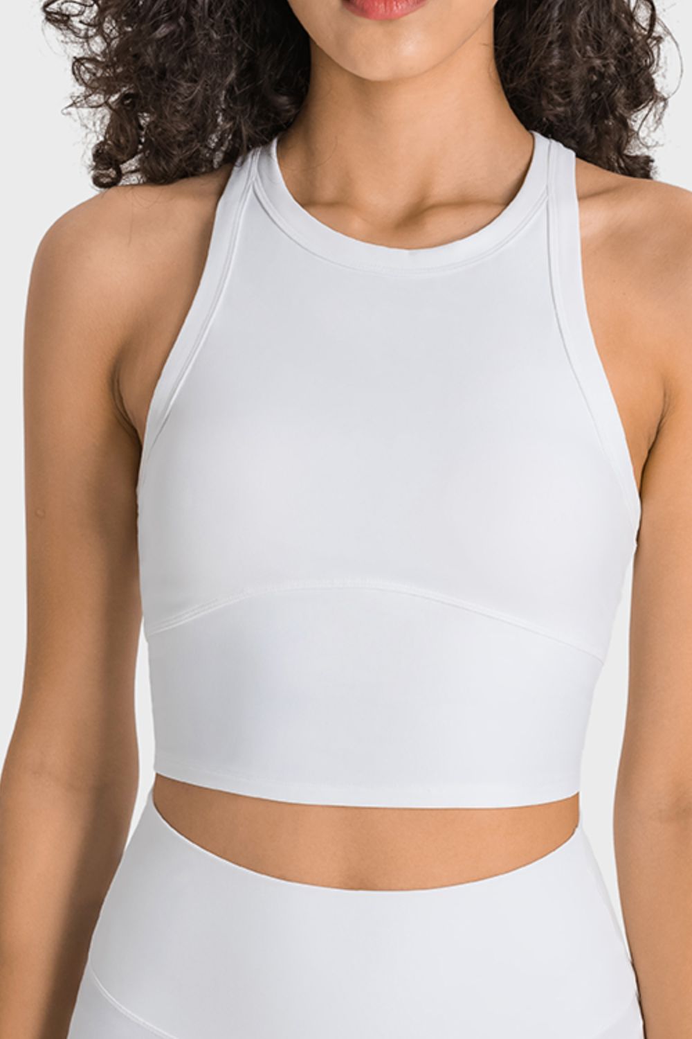 White racerback cropped sports tank with racerback straps and round neck.
