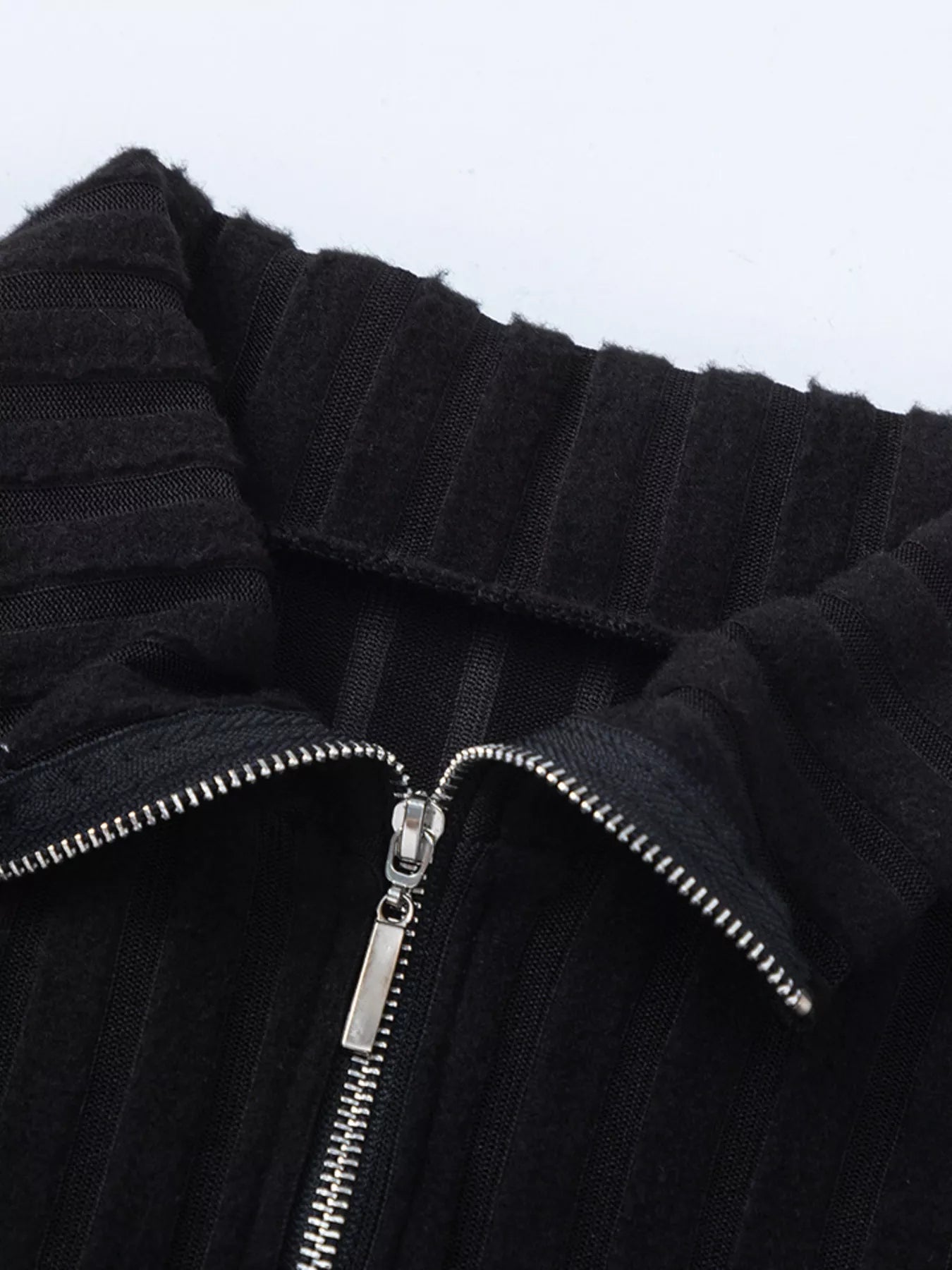 Black ribbed knit high collar and front zipper detail