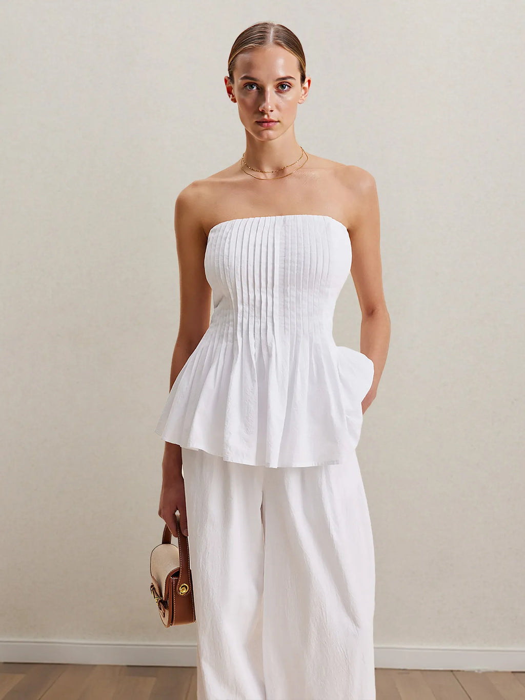 White strapless peplum top with smocked bodice and wide-leg pants, front view.