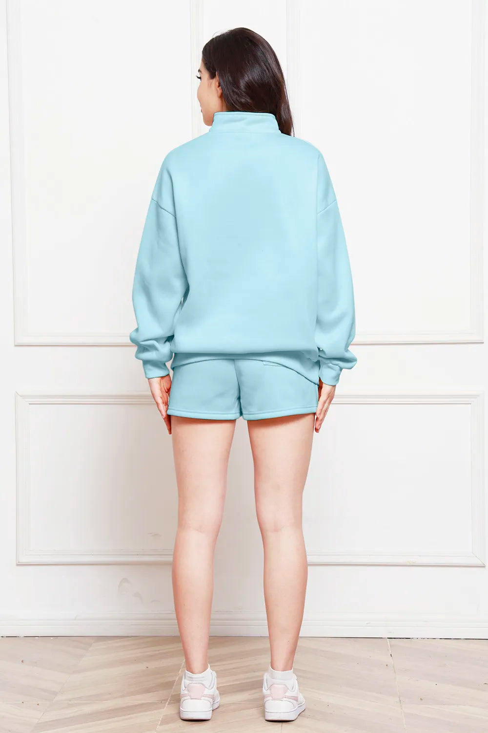 Light blue half-zip long-sleeve sweatshirt with matching drawstring shorts, back view.