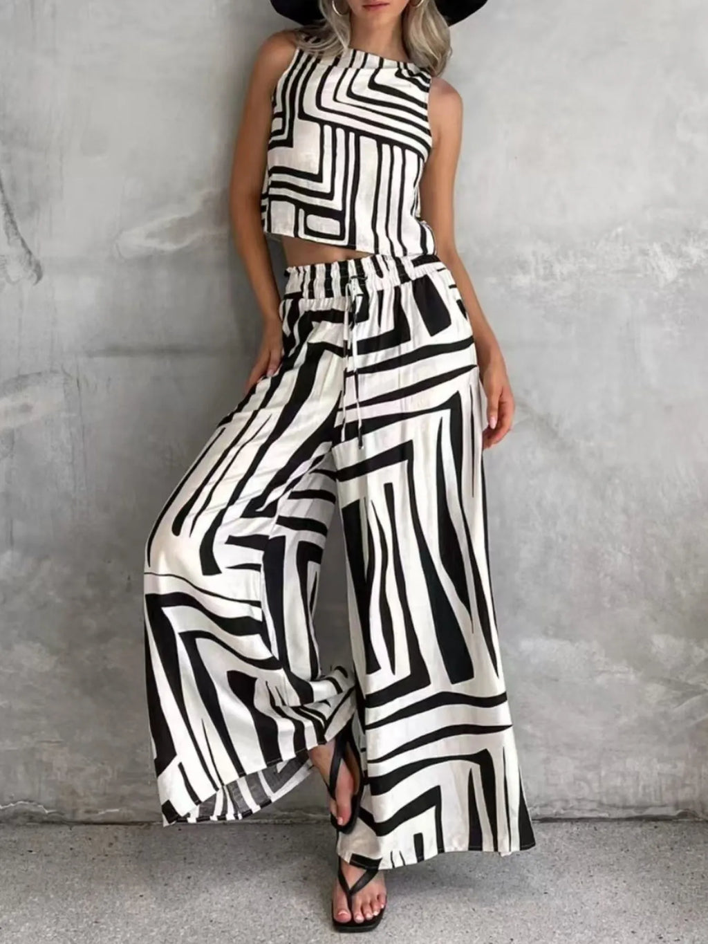Sleeveless geometric print crop top with wide-leg pants, black-and-white stripe print.