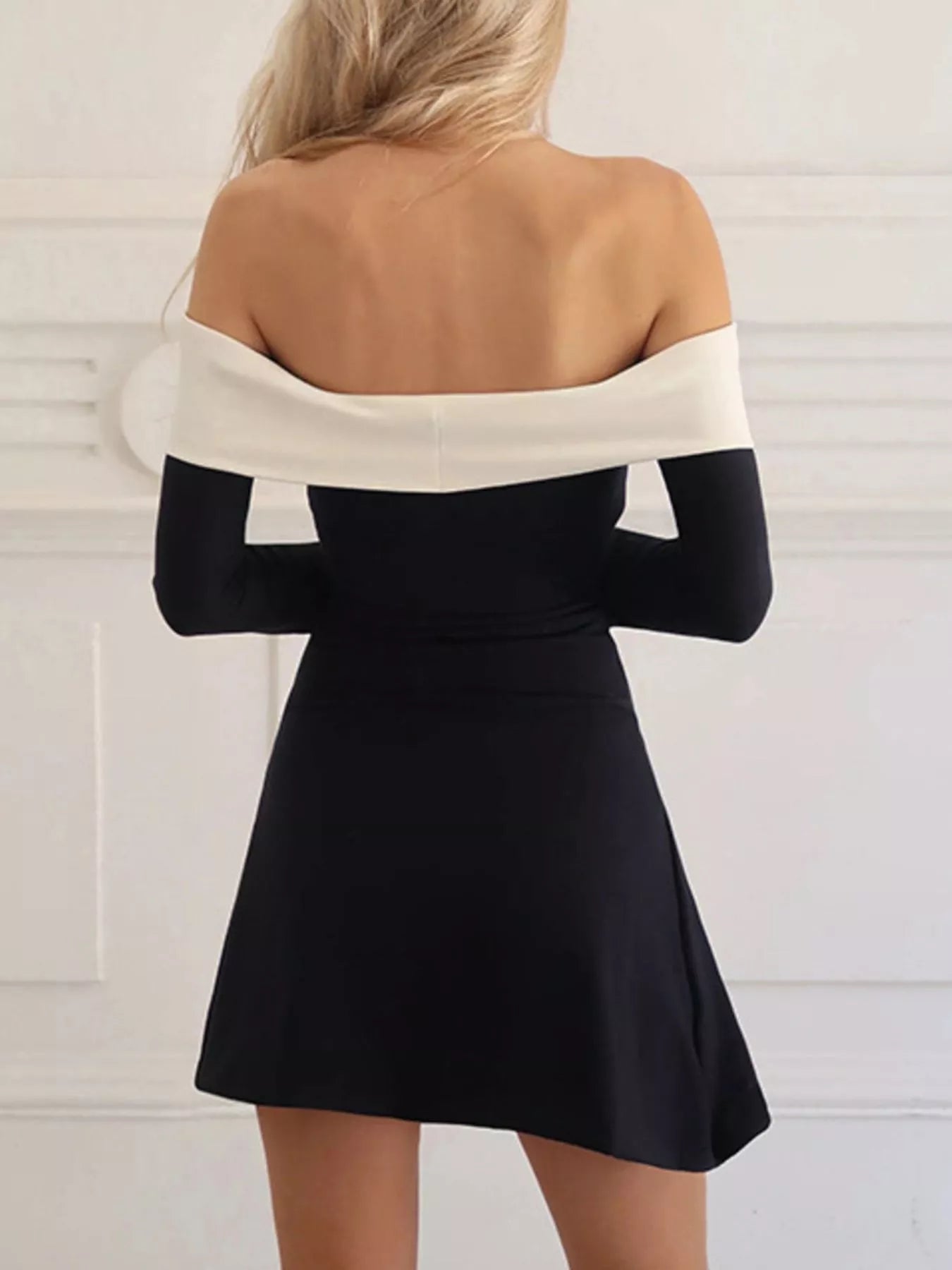 Black off-shoulder mini dress with white contrast band, back view, long sleeves