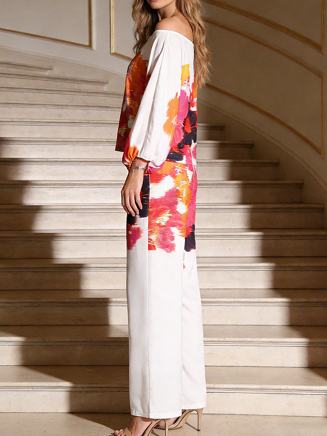 Back/side view: multicolor floral off-shoulder top with white wide-leg pants