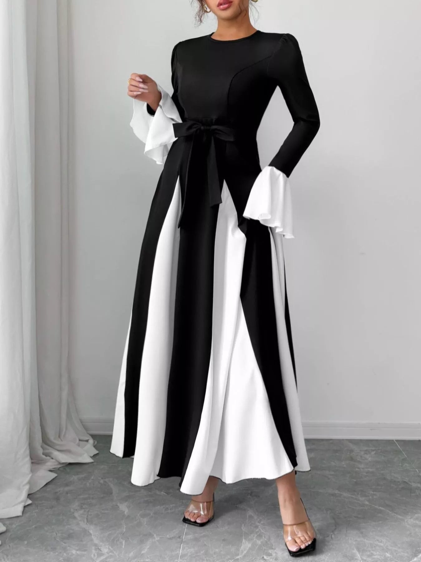 Black maxi dress with round neck, long flare sleeves, and white contrast panels at sides