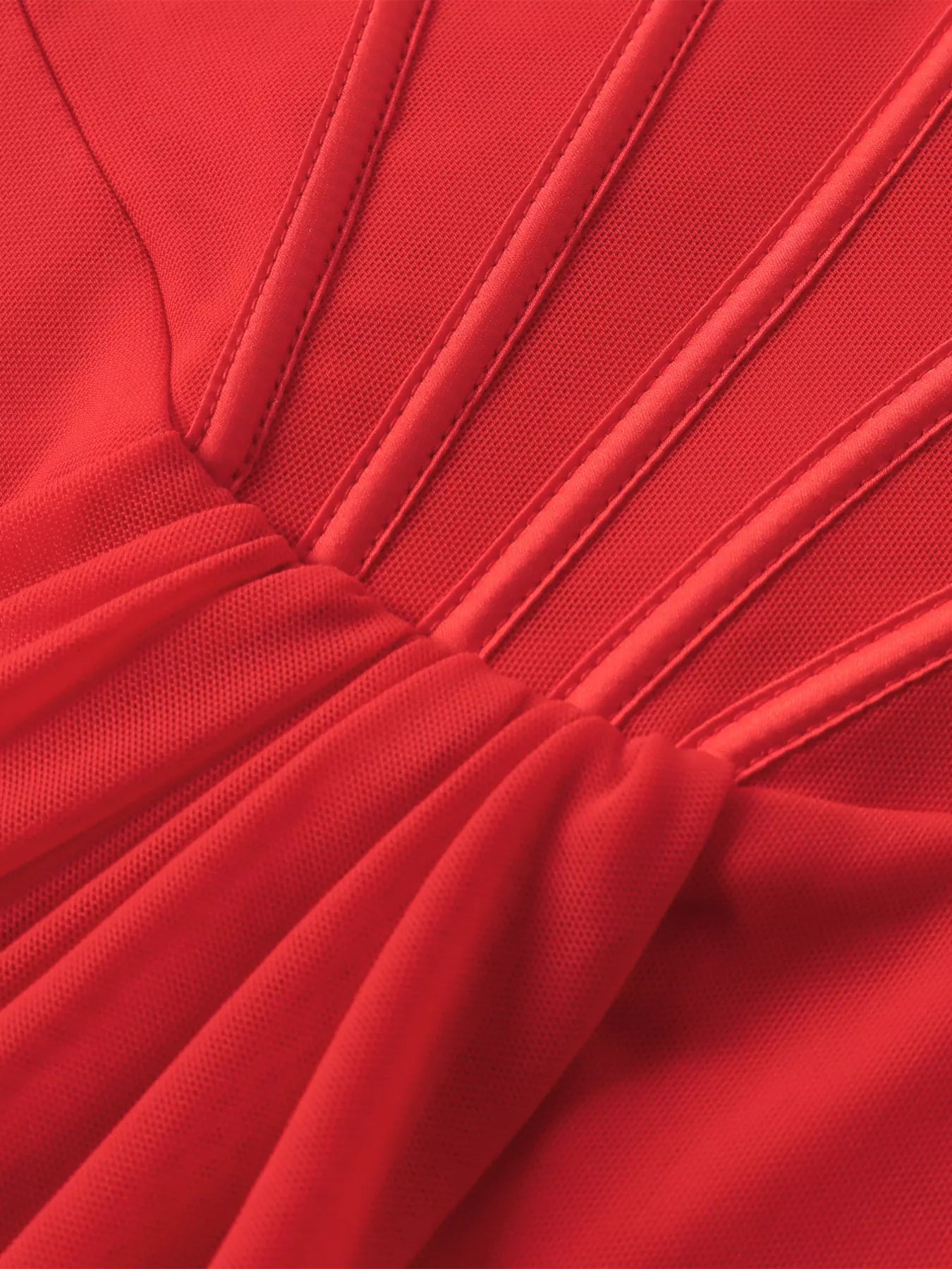 Close-up of red ruched mini dress fabric with vertical seam lines and gathered skirt