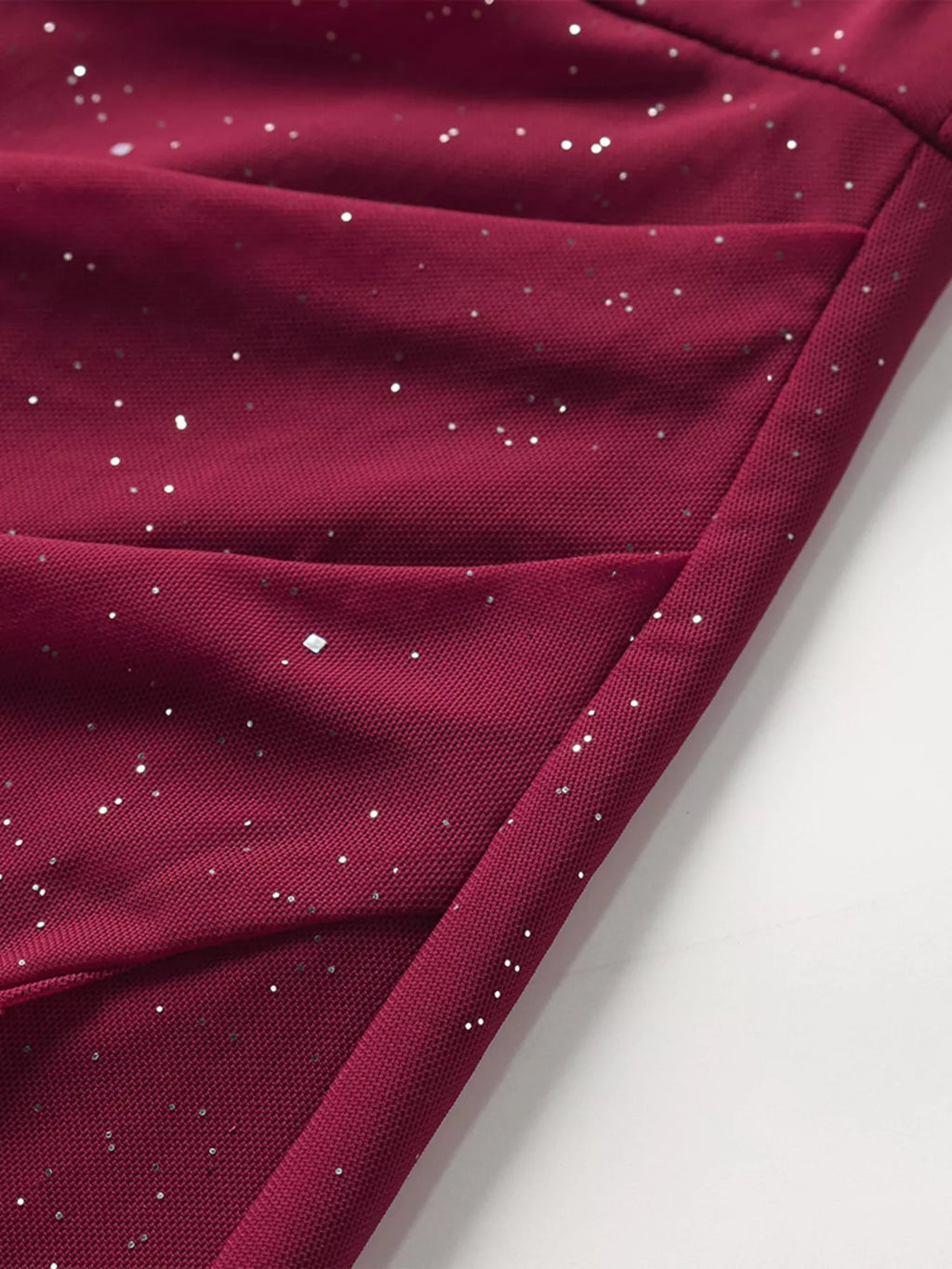 Burgundy glitter fabric with subtle drape and seam lines