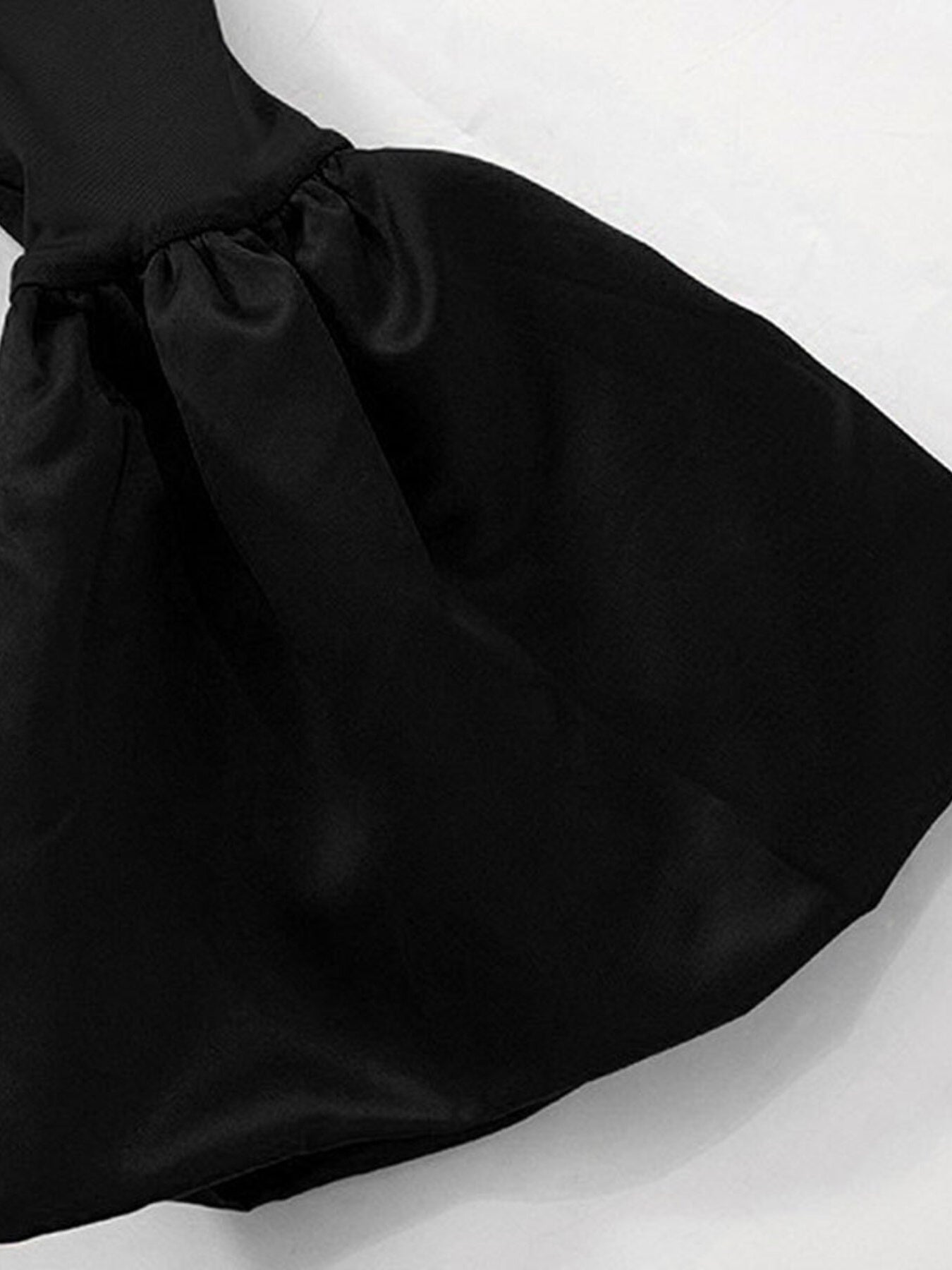Close-up of black gathered flounce sleeve cuff with ruffled detail