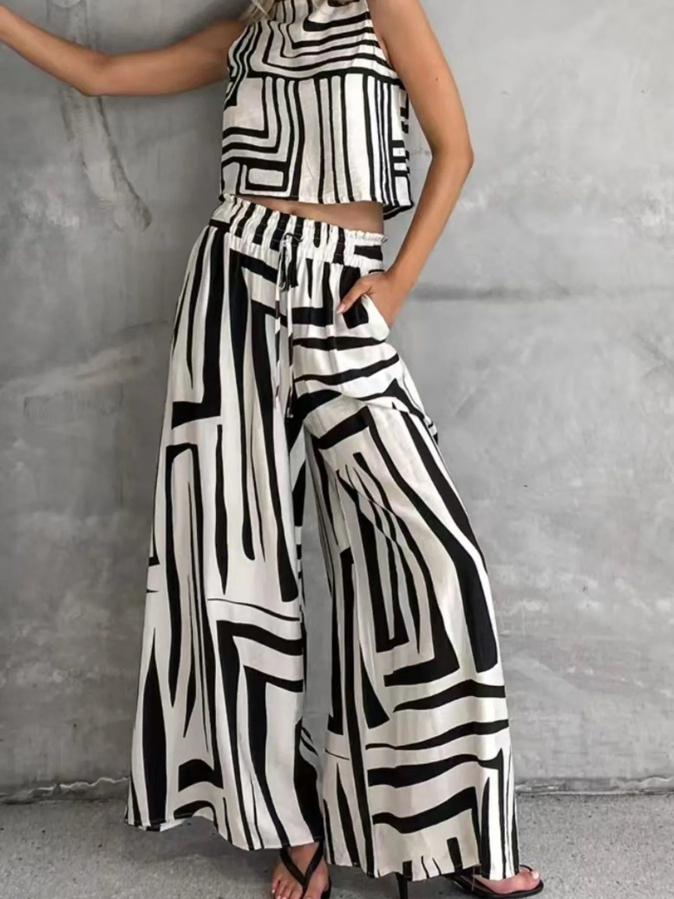 Geometric print sleeveless top and wide-leg pants set with bold black-and-white stripes.