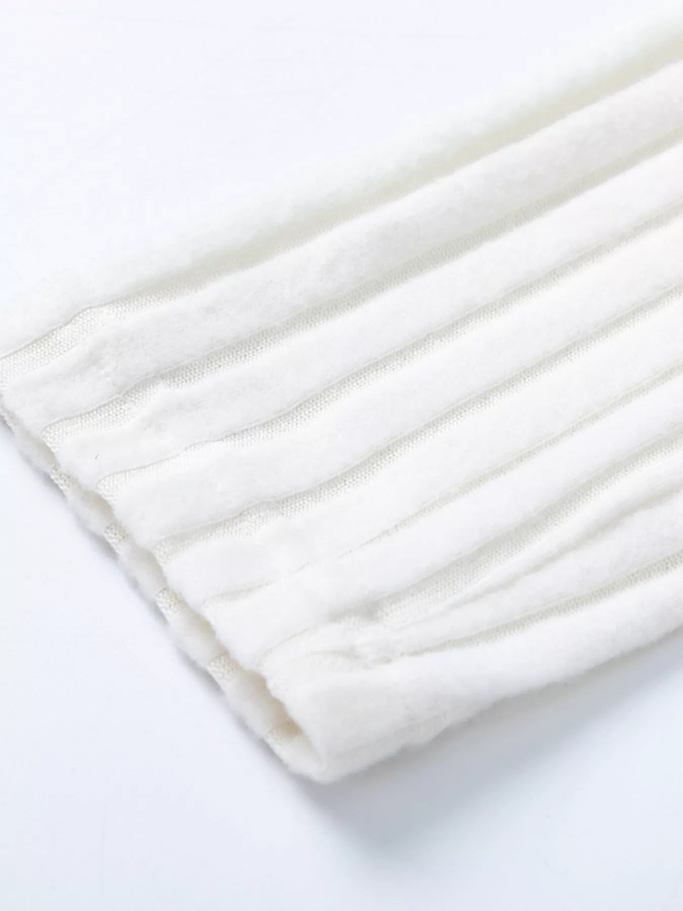 White ribbed knit fabric with soft texture and seam detail