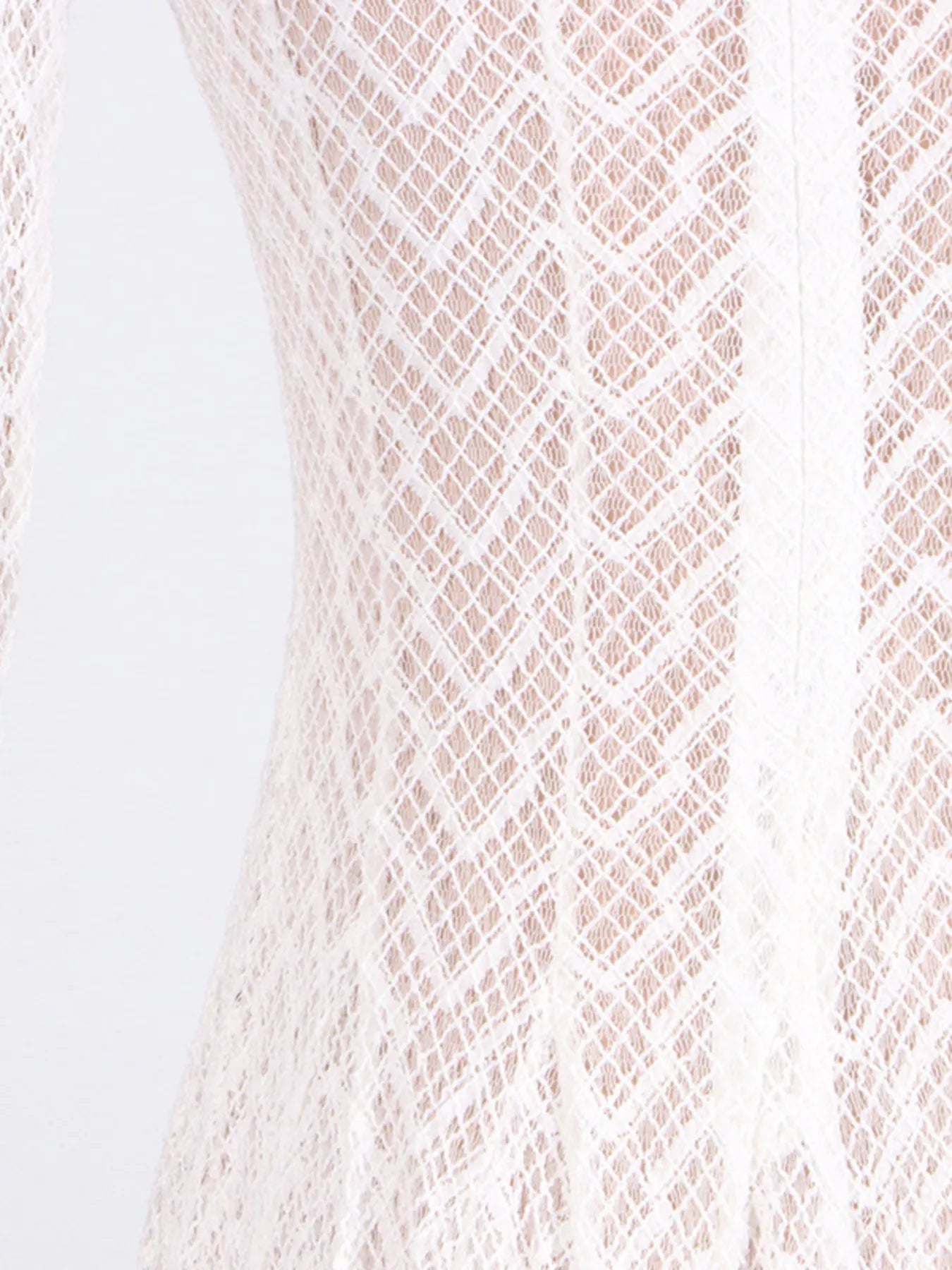 White lace dress fabric close-up at waist and skirt, textured diamond motif