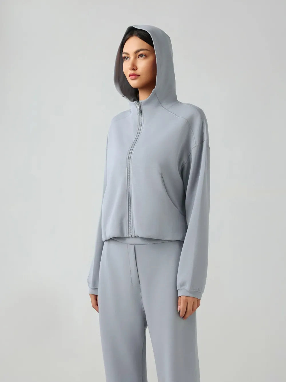 Light blue zip-up hooded active jacket with front zipper and relaxed dropped-shoulder fit.
