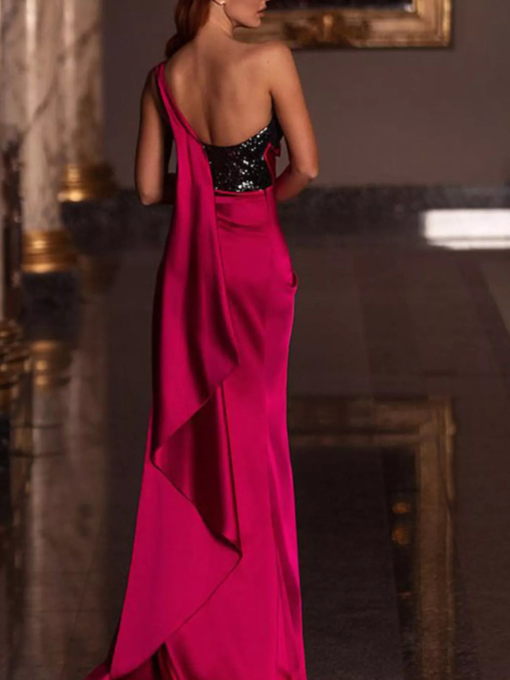 One-shoulder magenta satin gown with black sequin bodice and open-back detail