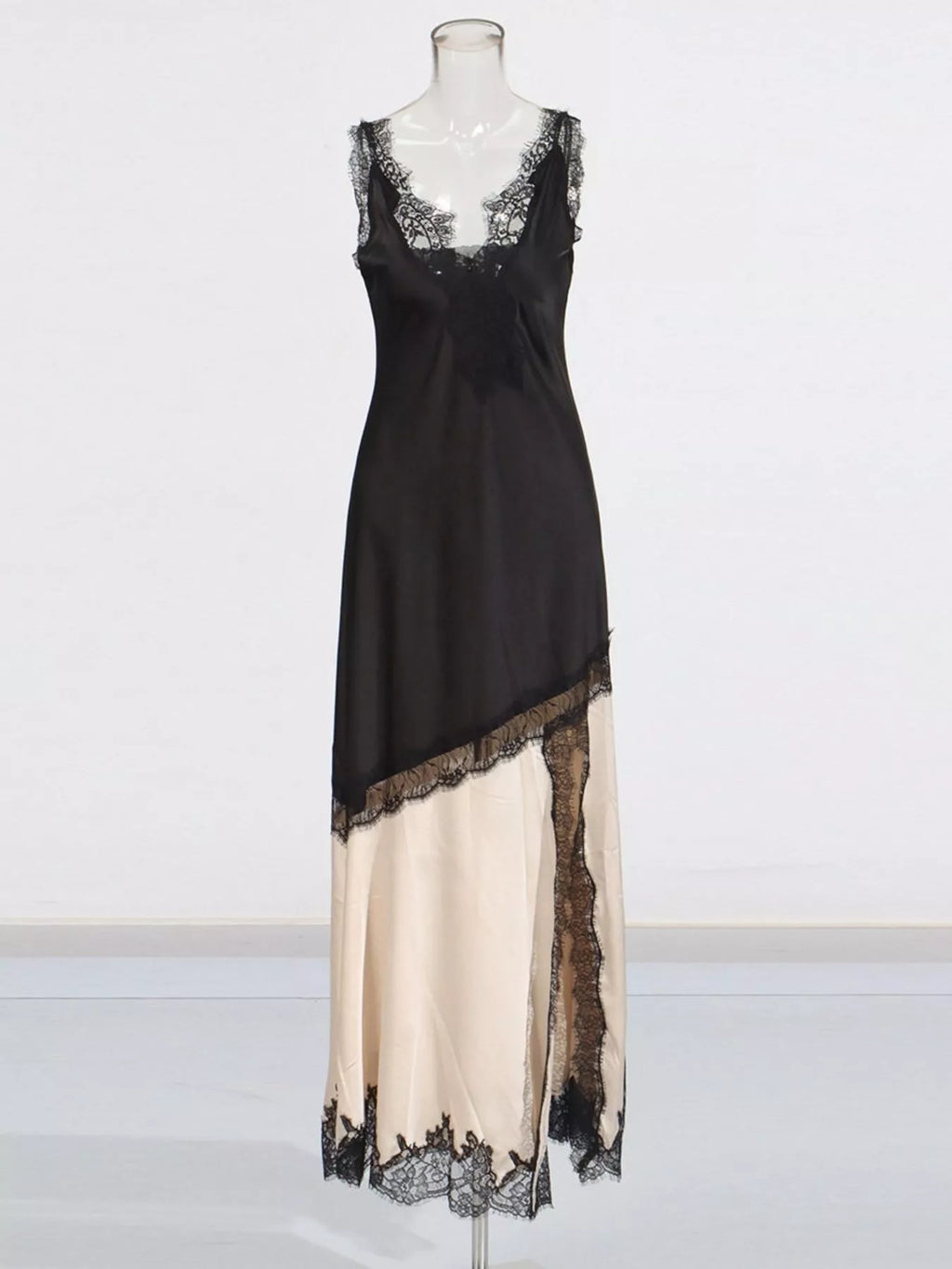 Two-tone lace-trim slip dress on mannequin, black upper and cream lower with lace border