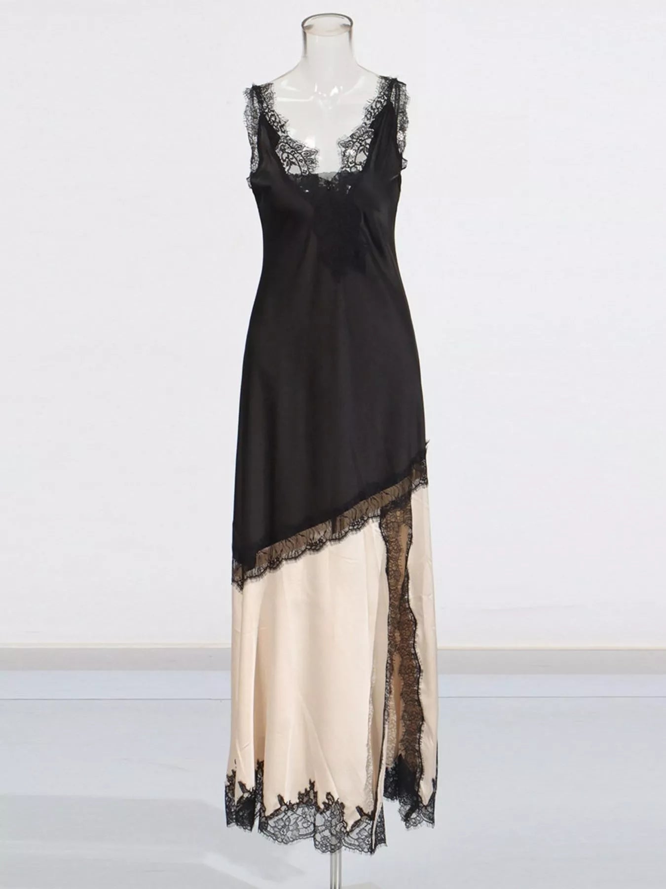 Two-tone lace-trim slip dress on mannequin, black upper and cream lower with lace border
