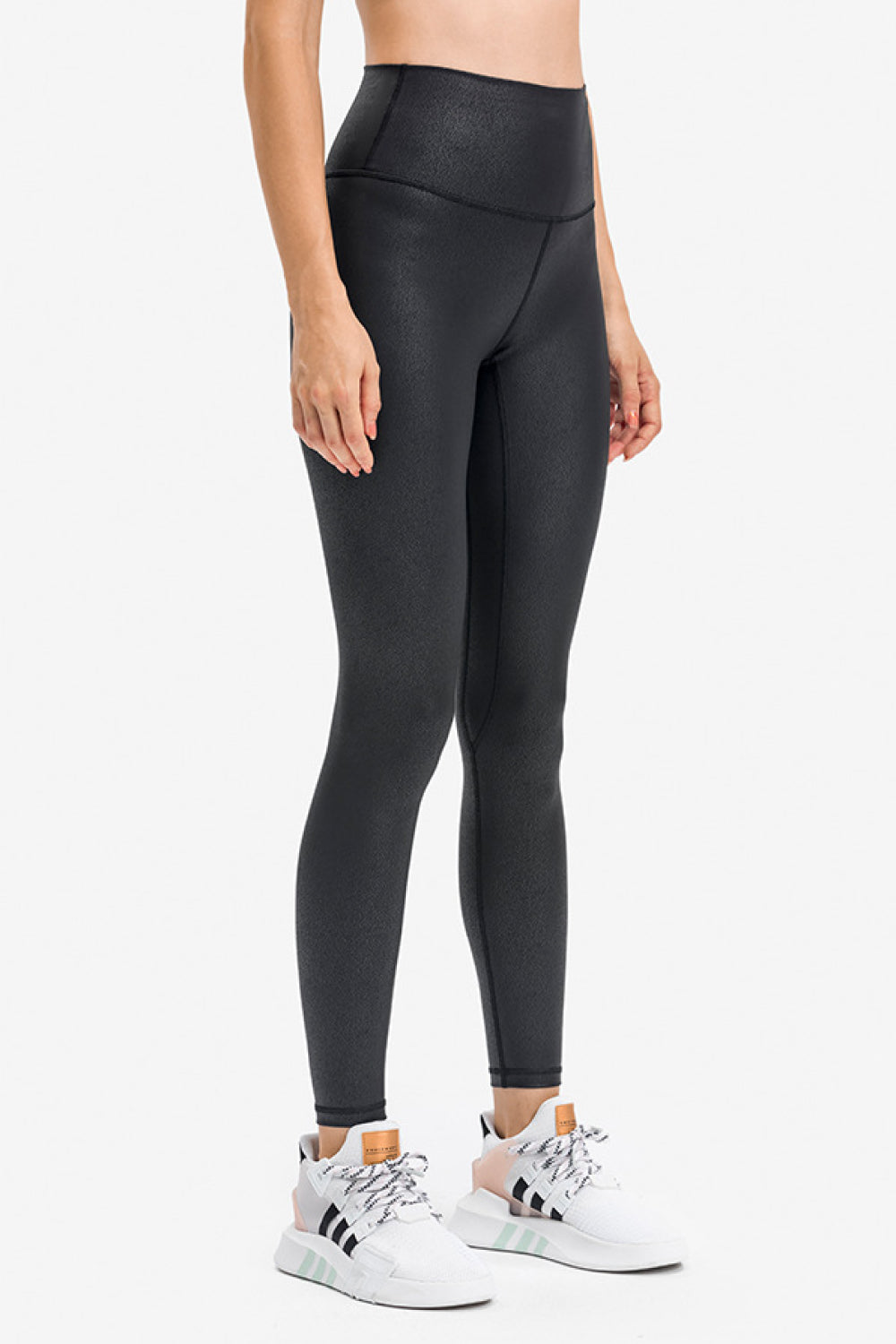 Black sports leggings with high-rise fit and subtle invisible pocket seam on side.