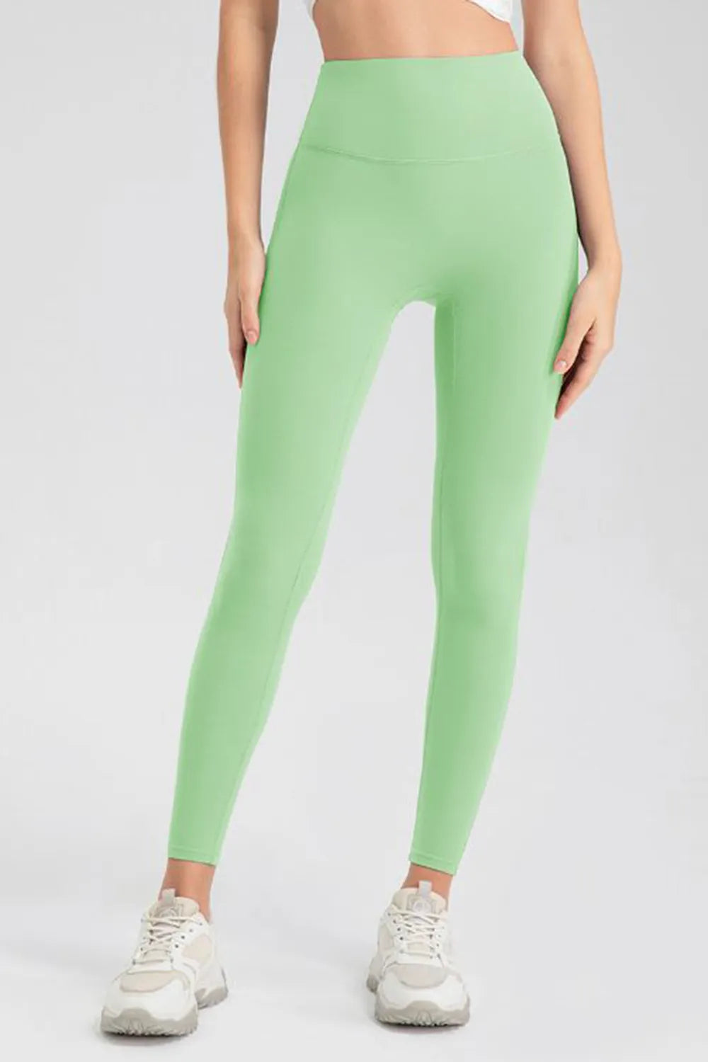 High-waist skinny active pants in mint green, full front view.