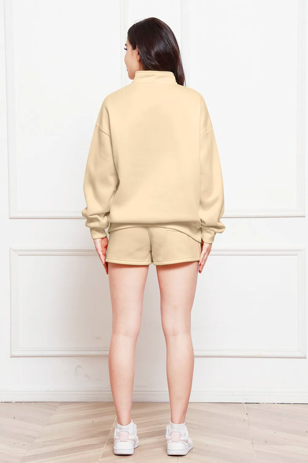 Ivory half-zip long-sleeve sweatshirt and drawstring shorts, back view.