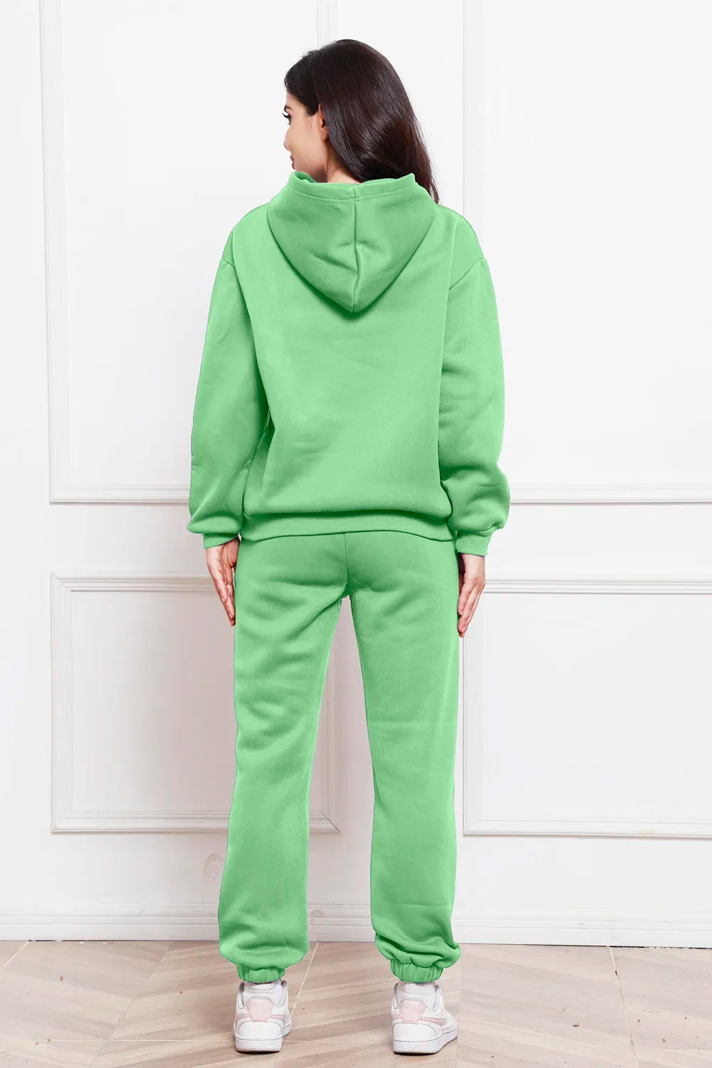 Hoodie and pants set in neon green, back view with hood and cuffed jogger legs