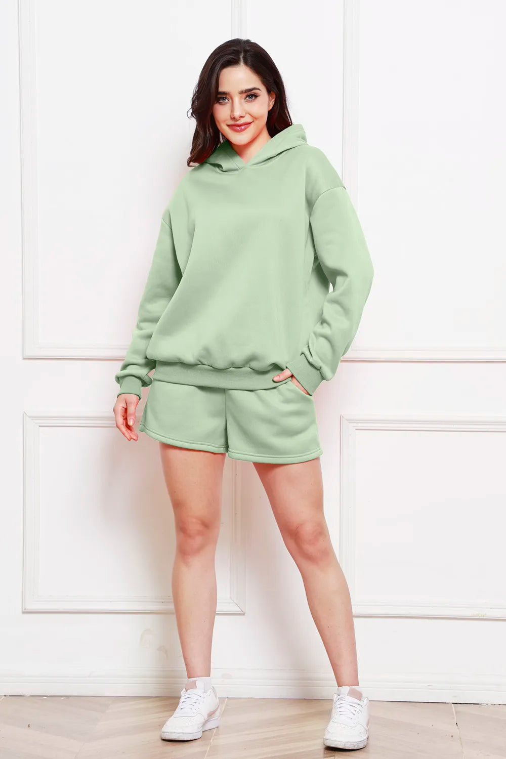 Sage green drop-shoulder hoodie with matching drawstring shorts set.