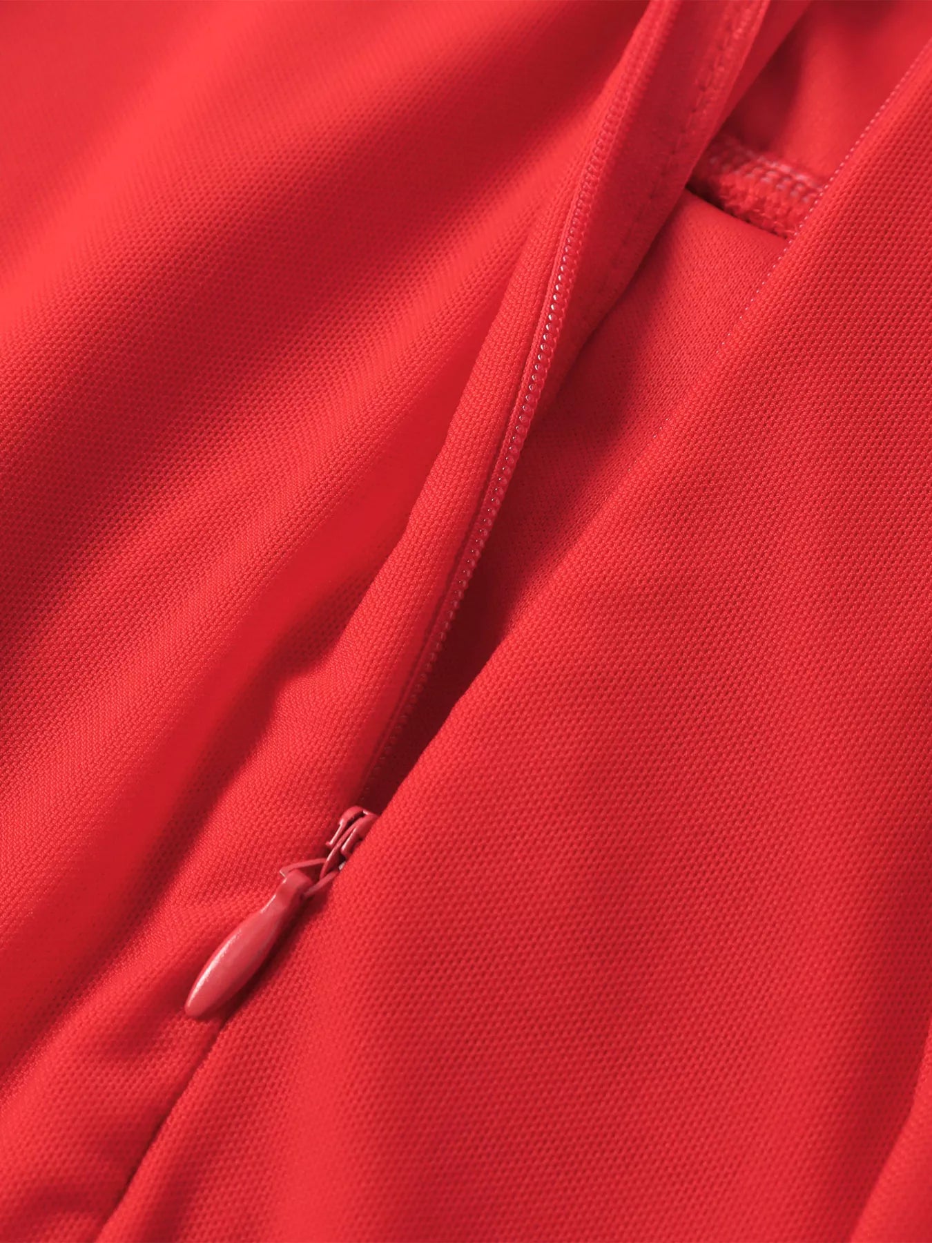 Close-up of red dress side seam and concealed zipper at skirt panel