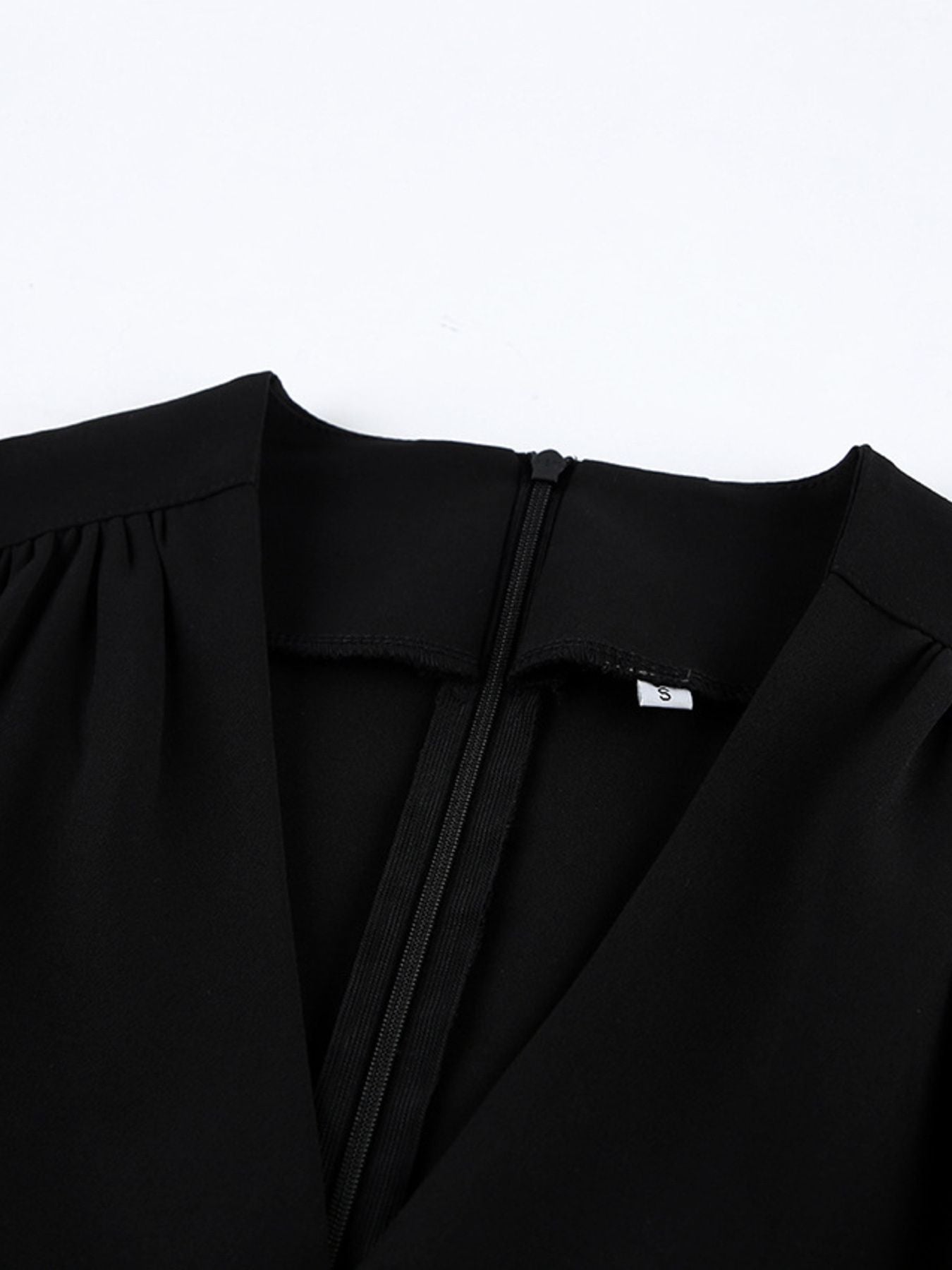 Black surplice V-neck dress with gathered neckline and smooth seam detailing.