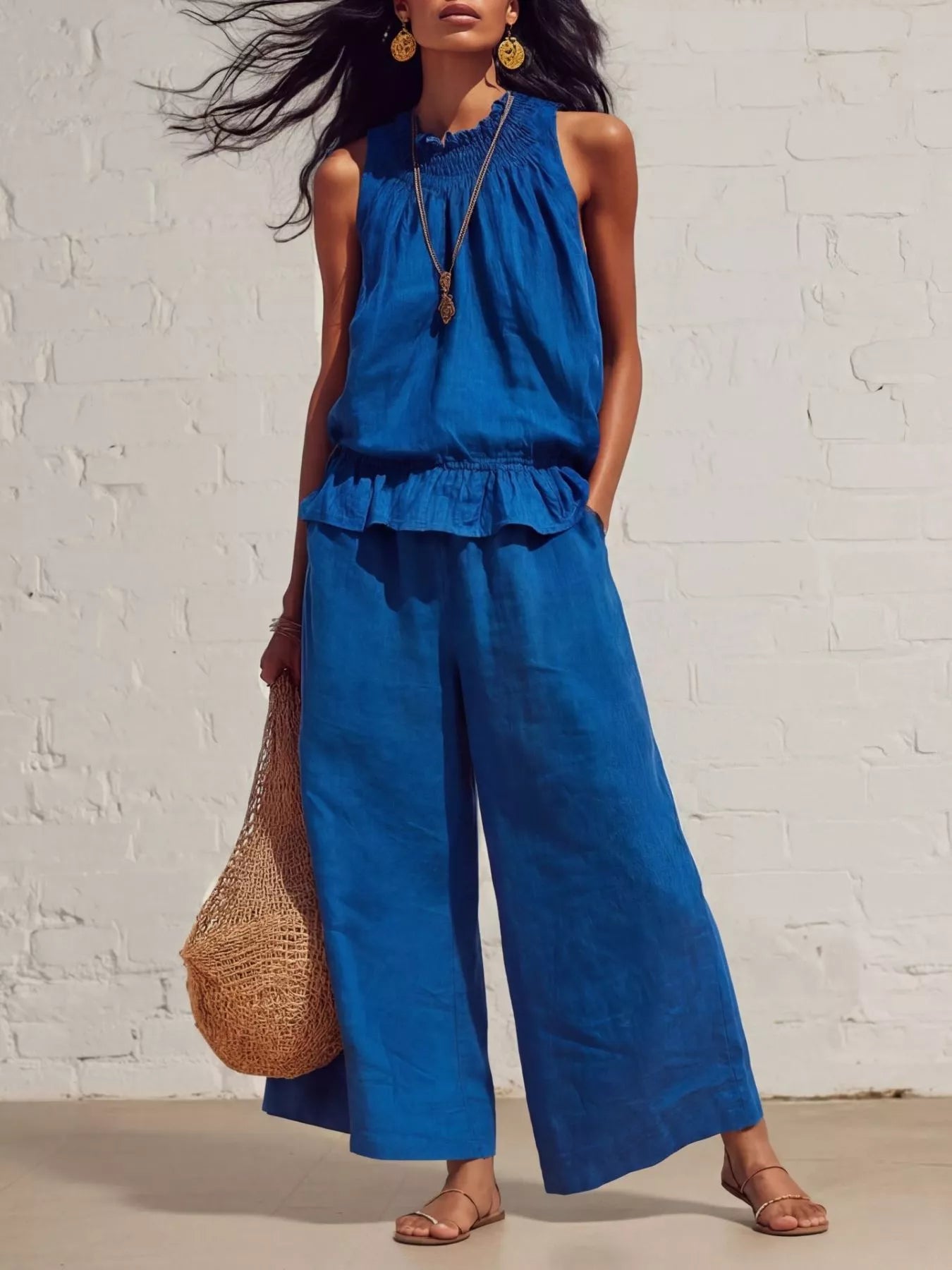 Blue sleeveless smocked ruffled hem top and wide-leg pants set with tiered bottom.