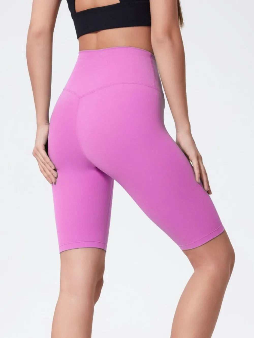 High-rise active shorts with wide waistband, bright pink, knee-length, back view